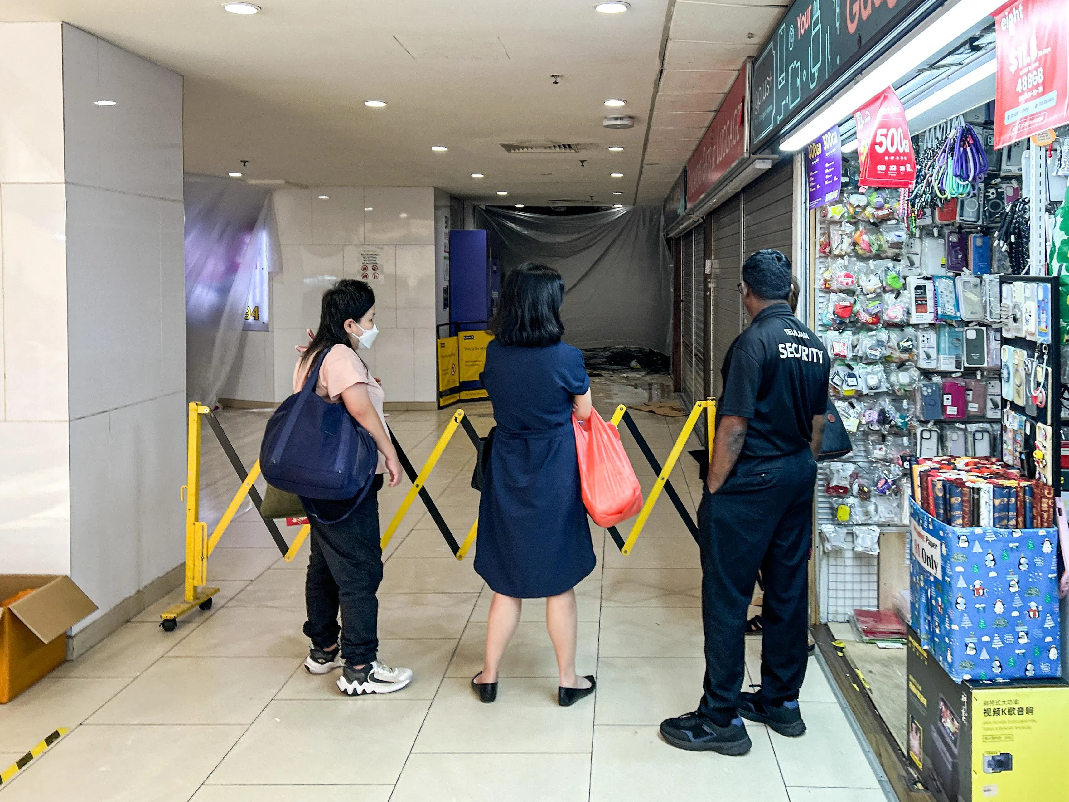 出事处附近拉起封锁线，保安人员在场引导公众绕道。（关俊威摄）