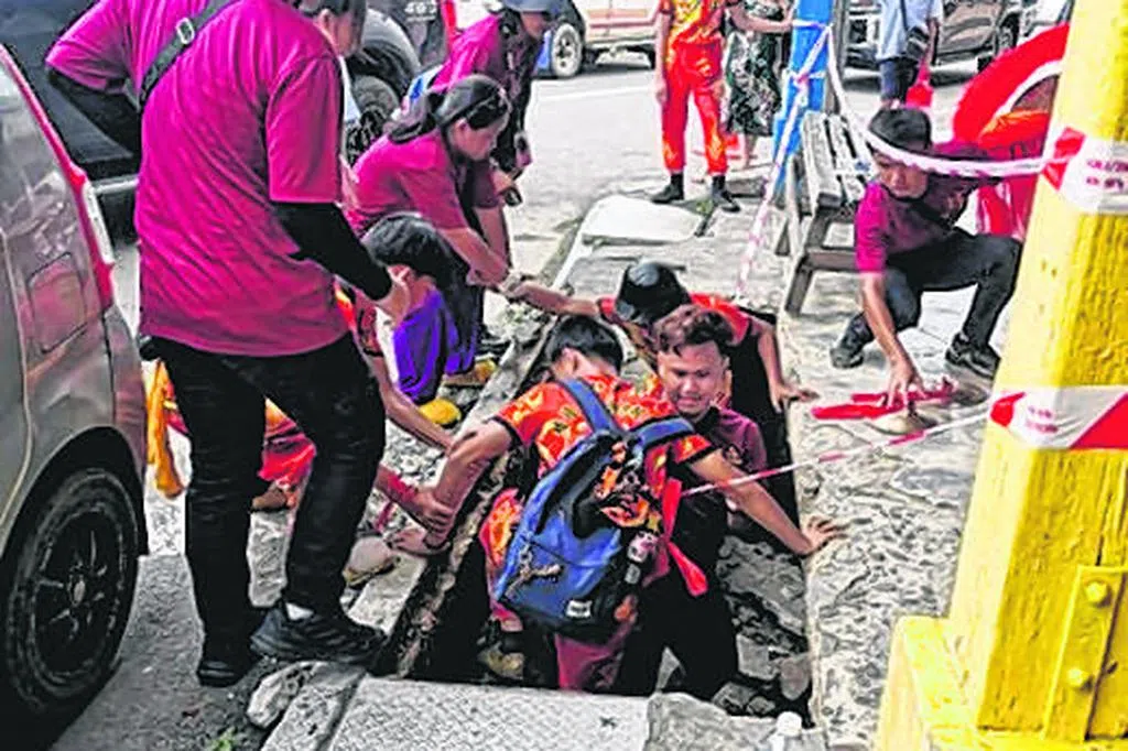 马国舞狮表演突遇地面塌陷 三人跌入坑洞