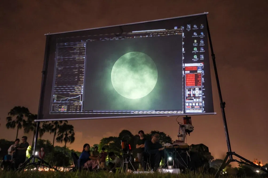 从9月7日深夜到8日凌晨，新加坡科学中心展览部经理孙少军和同伴们，在西海岸公园架起了能“跟着月亮走”的赤道仪，然后把天文望远镜安固定在上面，再把月亮的实时图像放大并投影到一块大屏幕上，为天文观测增加趣味。（关俊威摄）