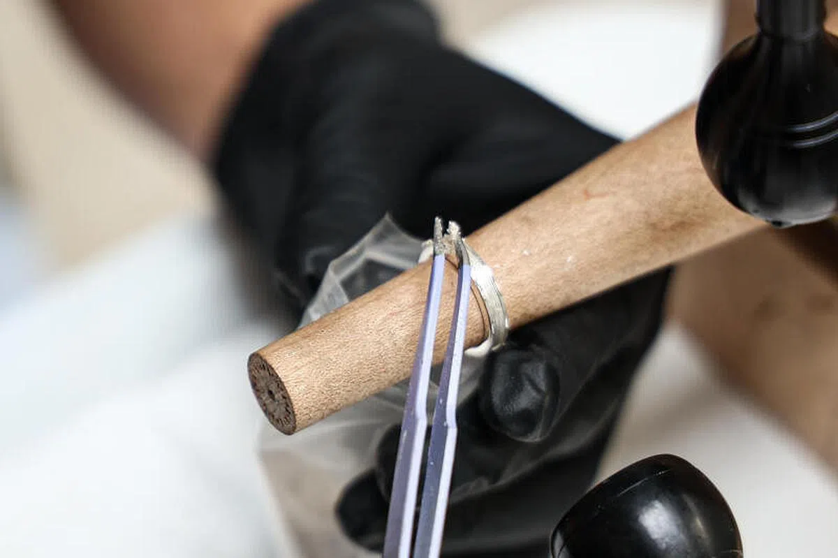 林宗翰将骨灰置入戒托的凹槽。（李健玮摄）