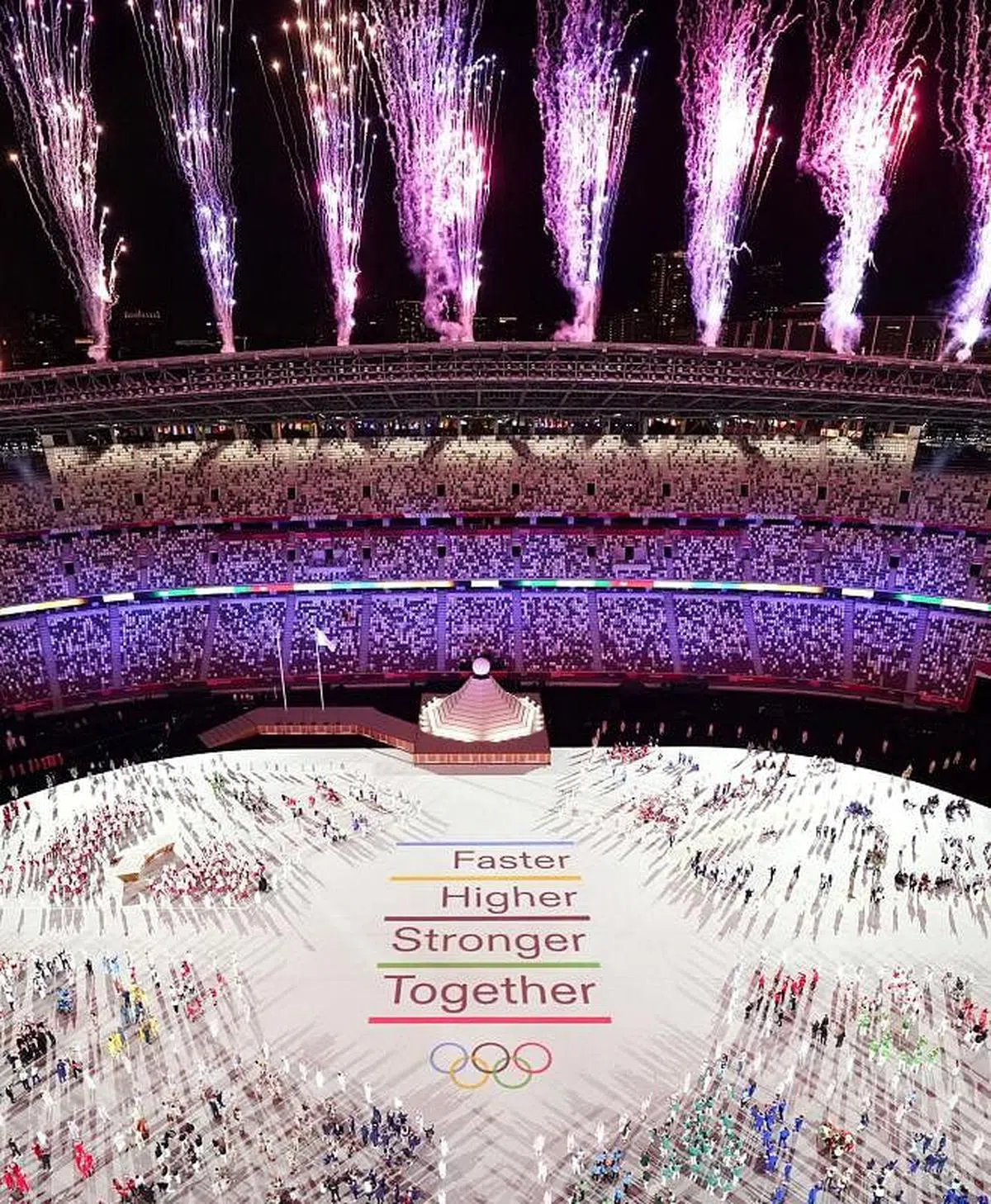 参加东京奥运会开幕式的各国运动员齐聚一堂，烟花绽放在奥运体育场上空。（路透社）