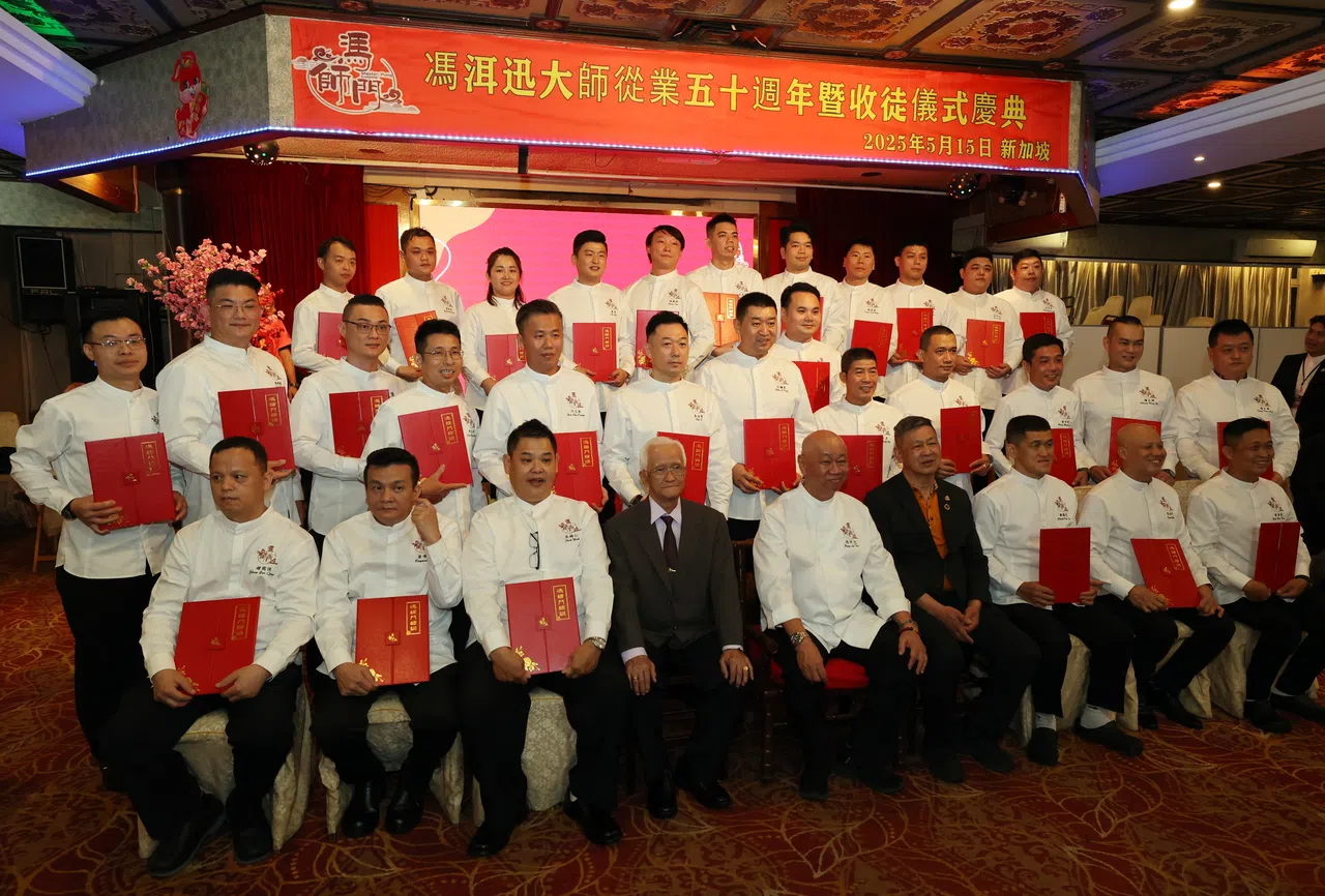 跟冯洱迅敬茶后，徒弟们手捧师训一起合照。 （刘启成摄）