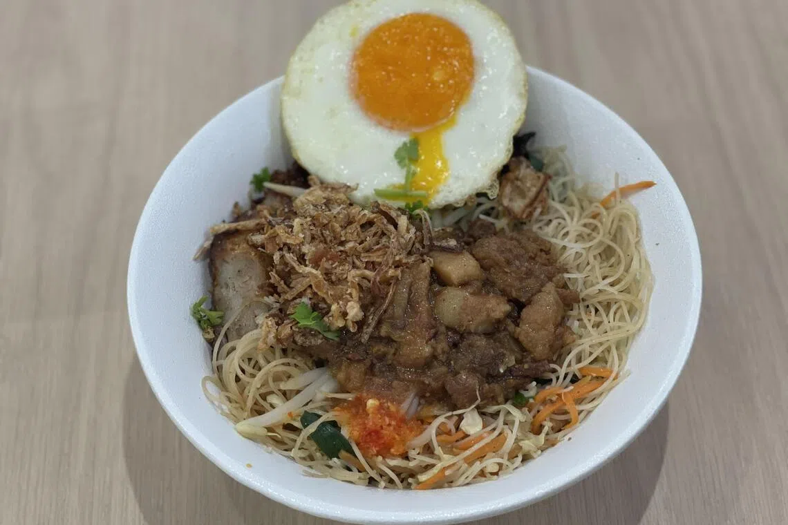 台式炒米粉，堆满煎荷包蛋、卤肉碎、炸五香等配料。