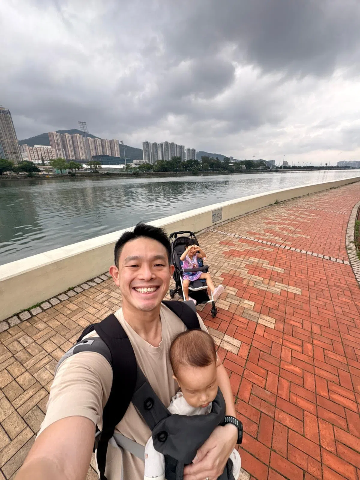 妻子因工作出国，裕廊东—武吉巴督集选区议员许德财毅然决定单枪匹马，首次独自带两个孩子到香港旅游四天三夜。他胸前背着13个月大的小儿子，手推车里是4岁的女儿，还给自己立下目标，全程乘搭公共交通，只能坐德士一次。（受访者提供）
