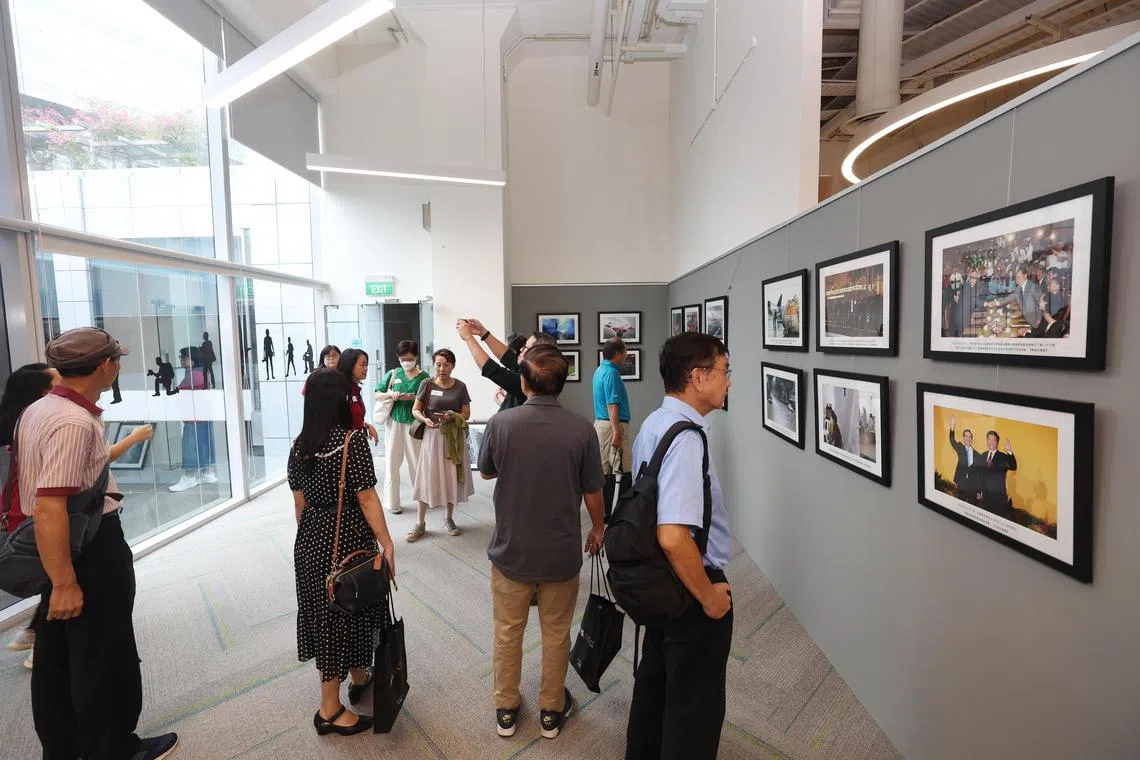 不少专栏作者在参观早报新闻室时，端详墙上展示的早报摄影记者拍摄的照片。（陈渊庄摄）