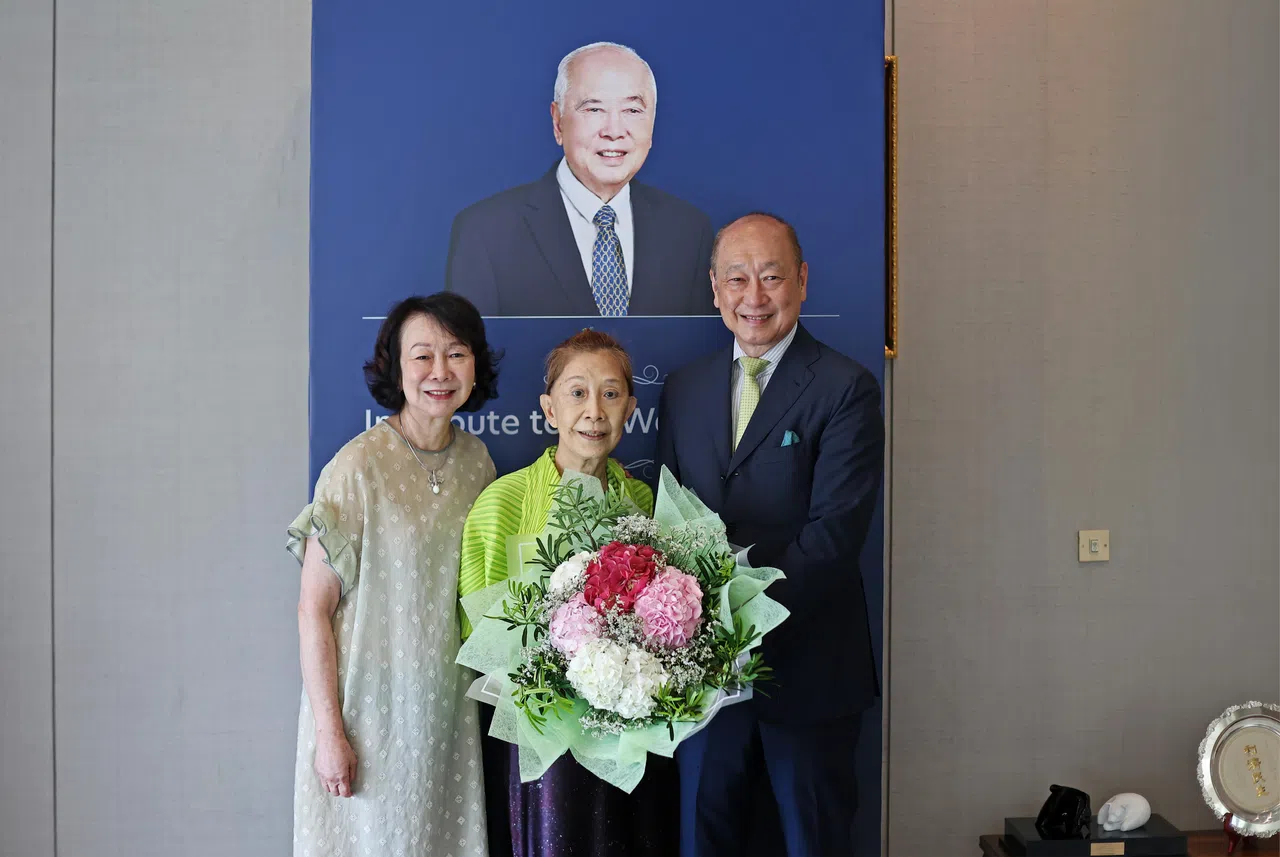 大华银行现任总裁黄一宗（右）说，谢美茹与父亲黄祖耀的关系是建立在“信任”二字上。黄祖耀长女黄玮玲（左）也送上一束鲜花，感谢退休的谢美茹尽心尽力。（陈渊庄摄）