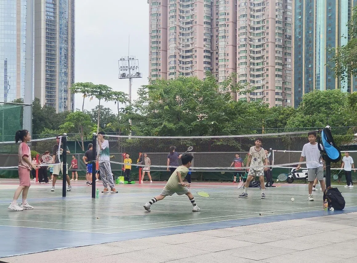 羽毛球运动兼具社交属性，是中国参与人数最多的体育运动之一。图为广州天河体育中心内民众在露天球场打羽毛球。（曾实摄）