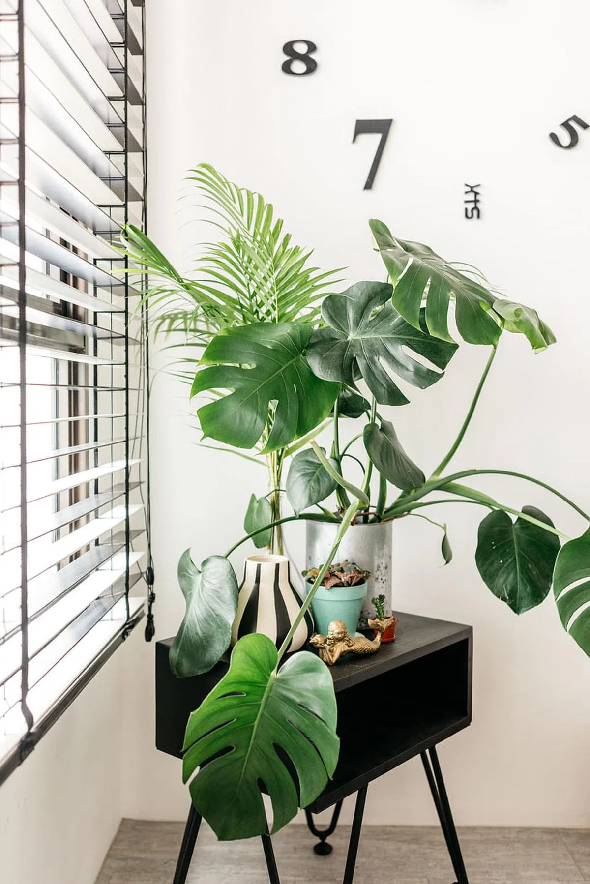 设计师把时钟装在不能动太多手脚的靠窗结构墙上，加入小茶几和室内植物，隔出小角落，让客厅看起来不太单调。（木美室内设计工作室提供图片）