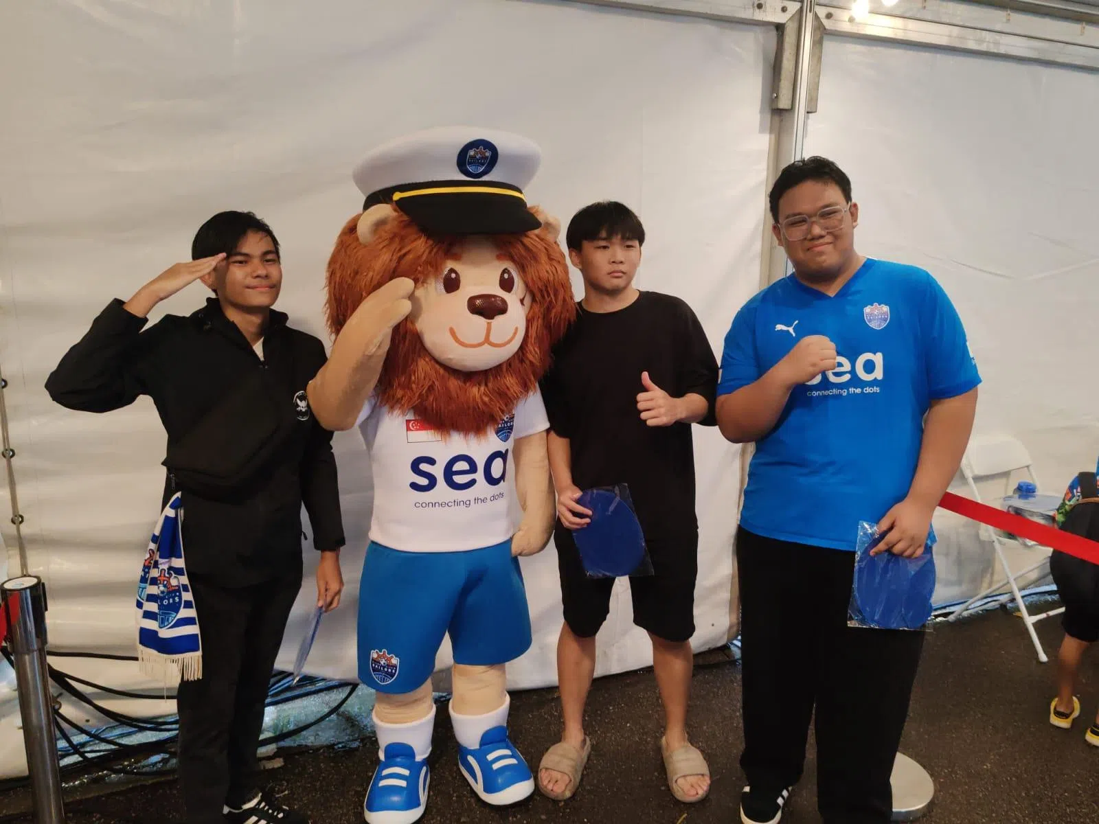 狮城水手吉祥物Helix（左二）在场外和到场的观众合影互动。（陈明耀摄）