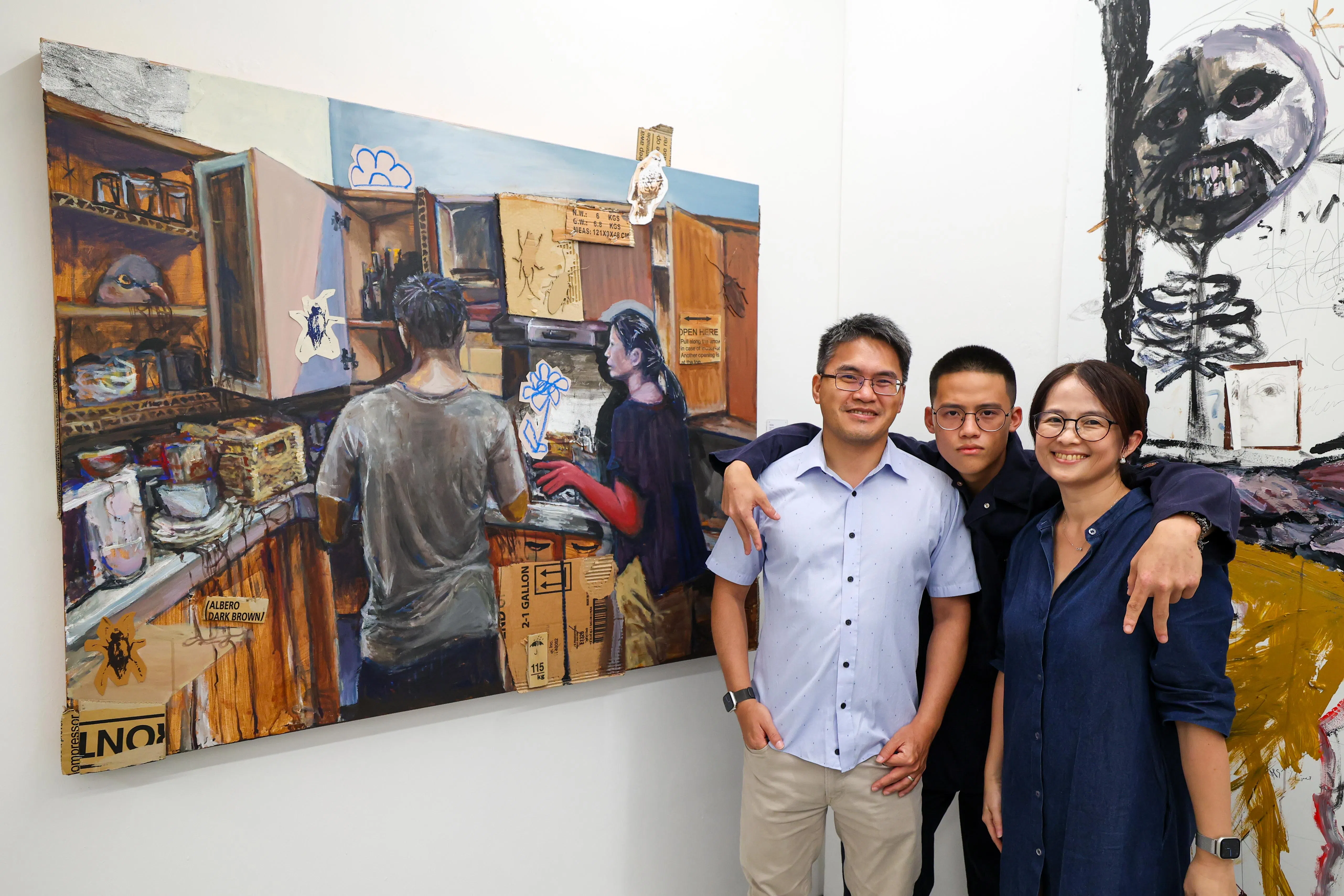 叶容硕（中）与父亲叶原光，母亲郑媛元在作品《家》前合影。画中呈现的是他在最近一次搬家时捕捉到父母在新居中整理的背影。（林明顺摄）