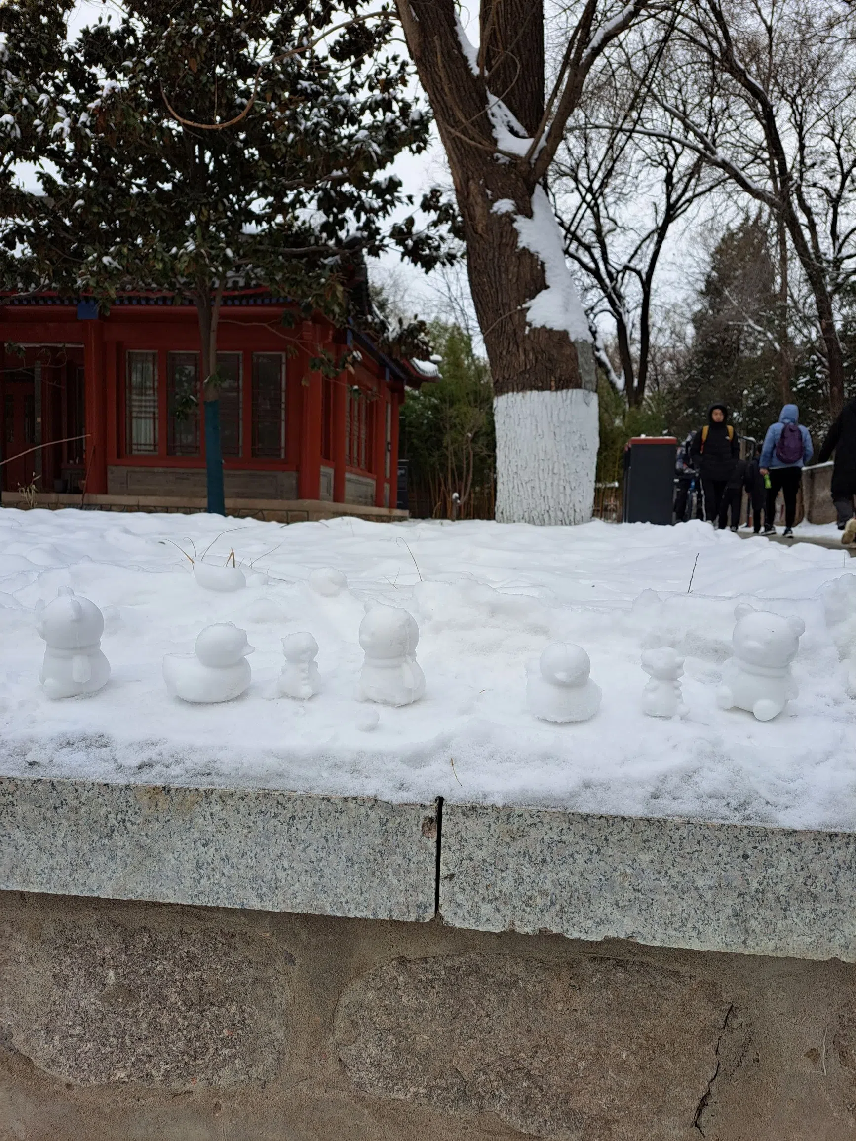 穿过学校的燕南园，矮石墙上陈列着用雪堆成的小鸭子、小恐龙。（作者提供）
