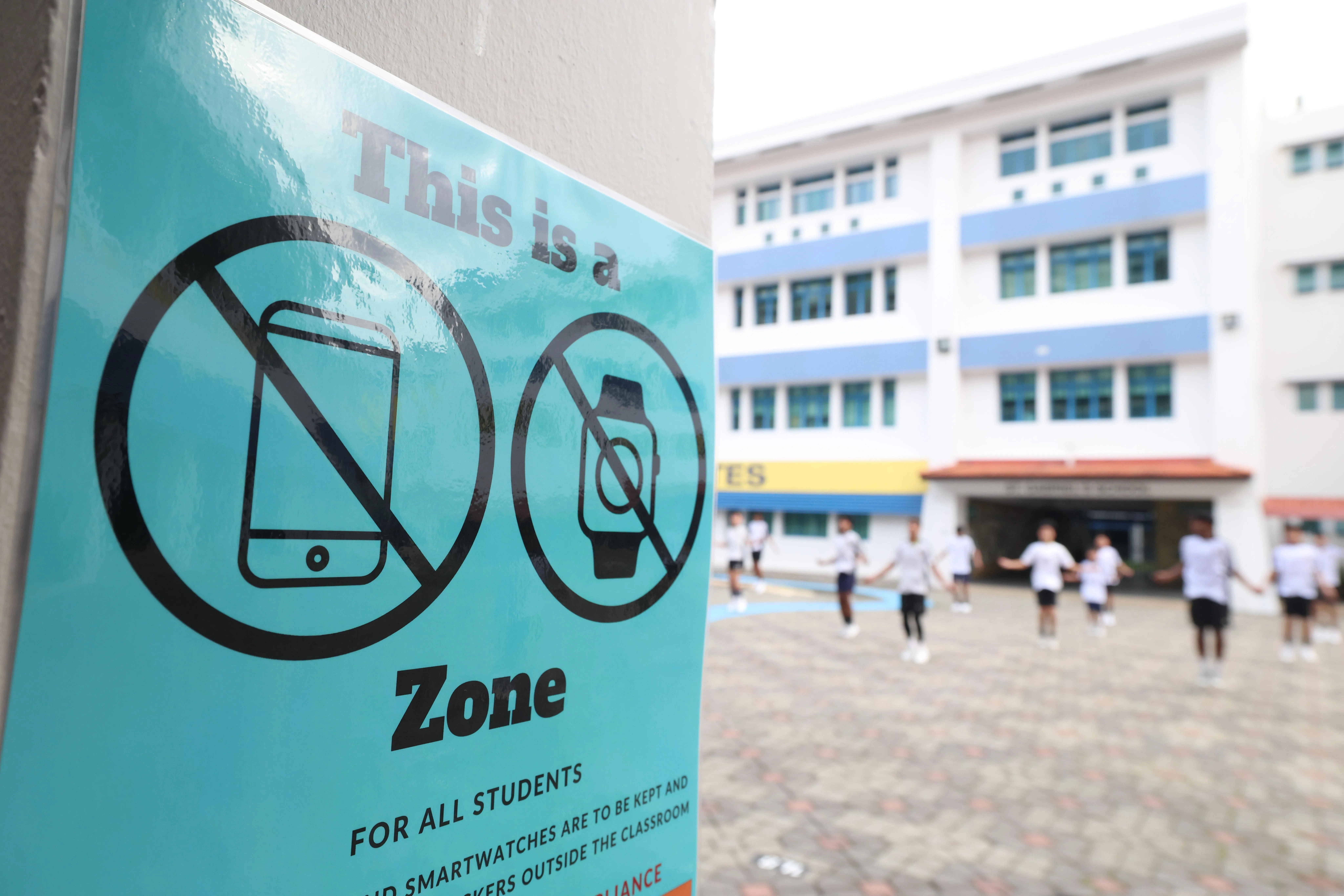 圣加俾尔中学校园内张贴了海报，提醒学生在校期间不得使用智能手机和手表。（郑一鸣摄）