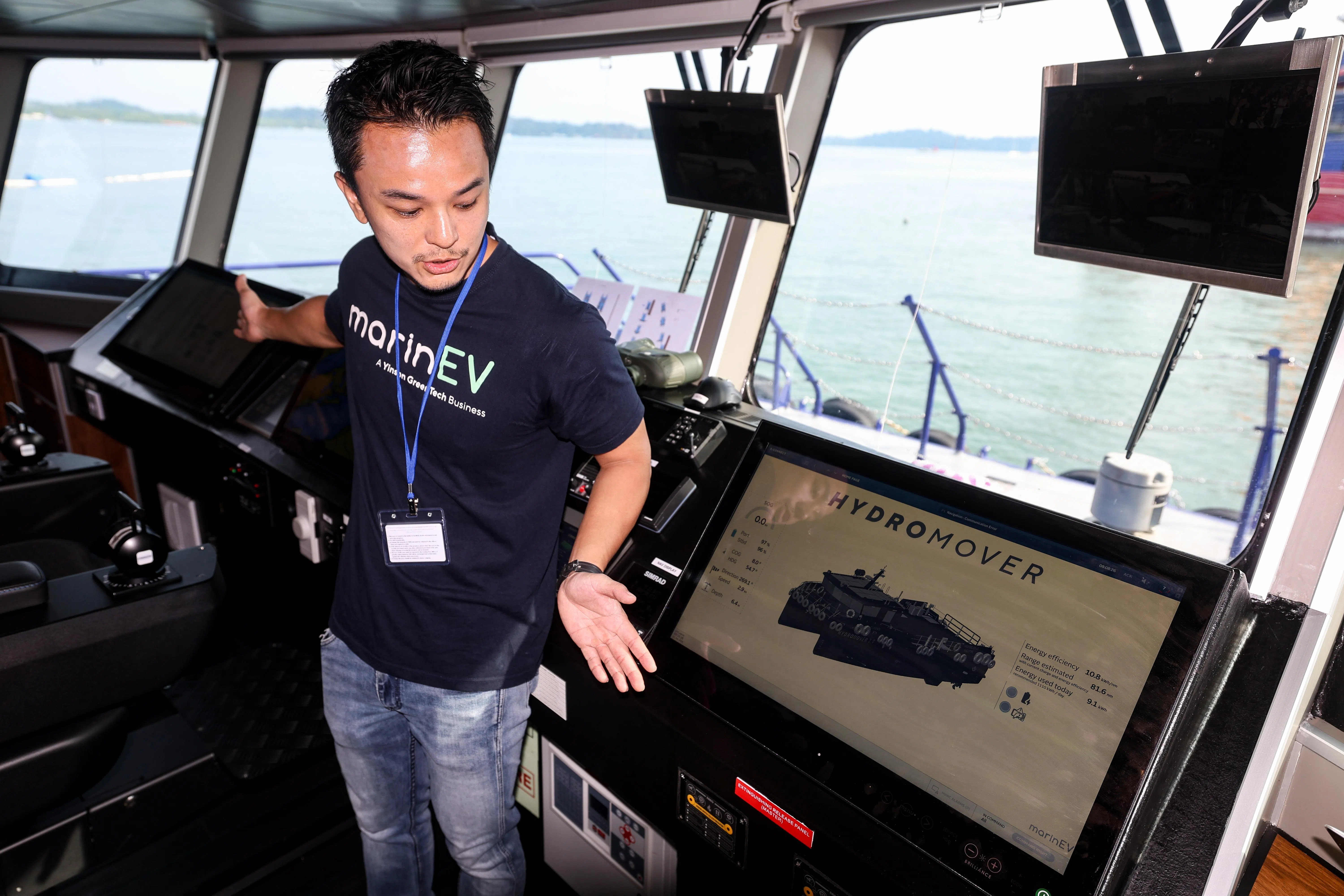 MarinEV的代表介绍电动船Hydromover2.0的船上设备，包括可触屏操作的电子屏幕进行导航控制与舵机操作。屏幕显示船只实时的电池电量消耗状态、电池储能系统温度和防火安全状态等。（关俊威摄）