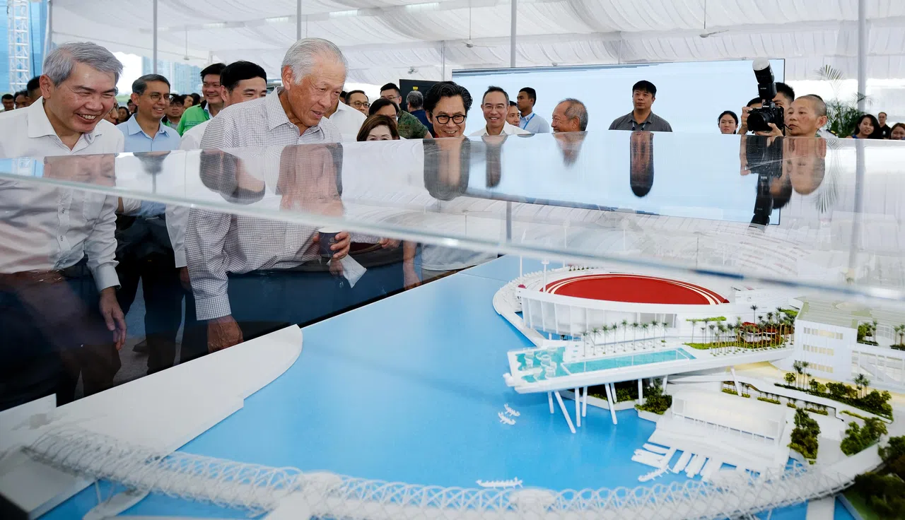 国防部长黄永宏医生（左二）与卫国广场董事会主席林明彦（左一）一同观看广场的全景模型，了解广场的设计与建造思路。（曾坤顺摄）