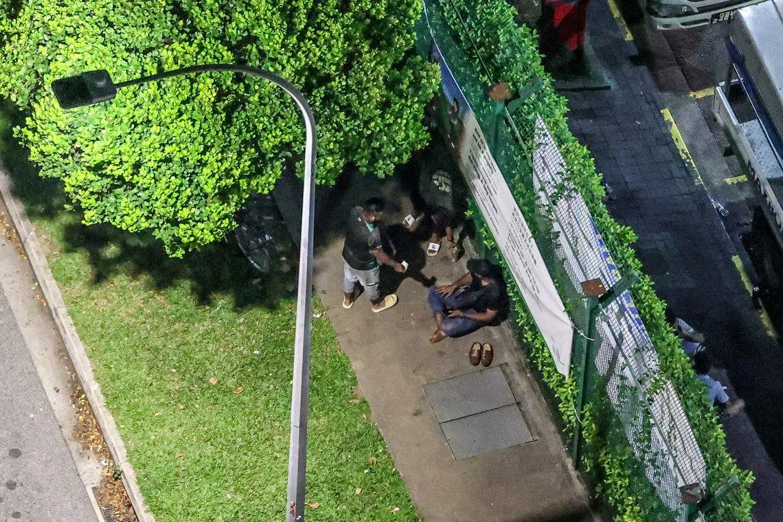 黑衣男子主要坐着负责收钱，而另一人则负责拿货。（关俊威摄）