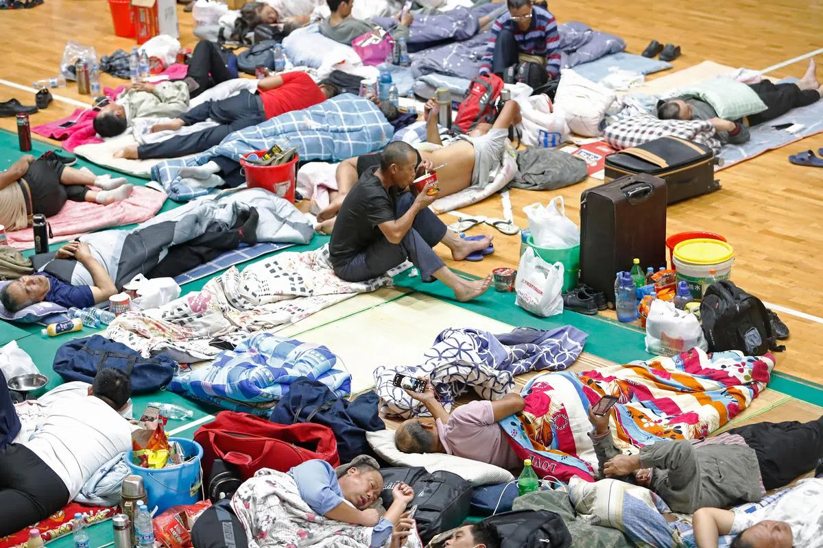 在临港新片区工作的员工被安置在上海建桥学院的体育馆内避灾。（中新社）