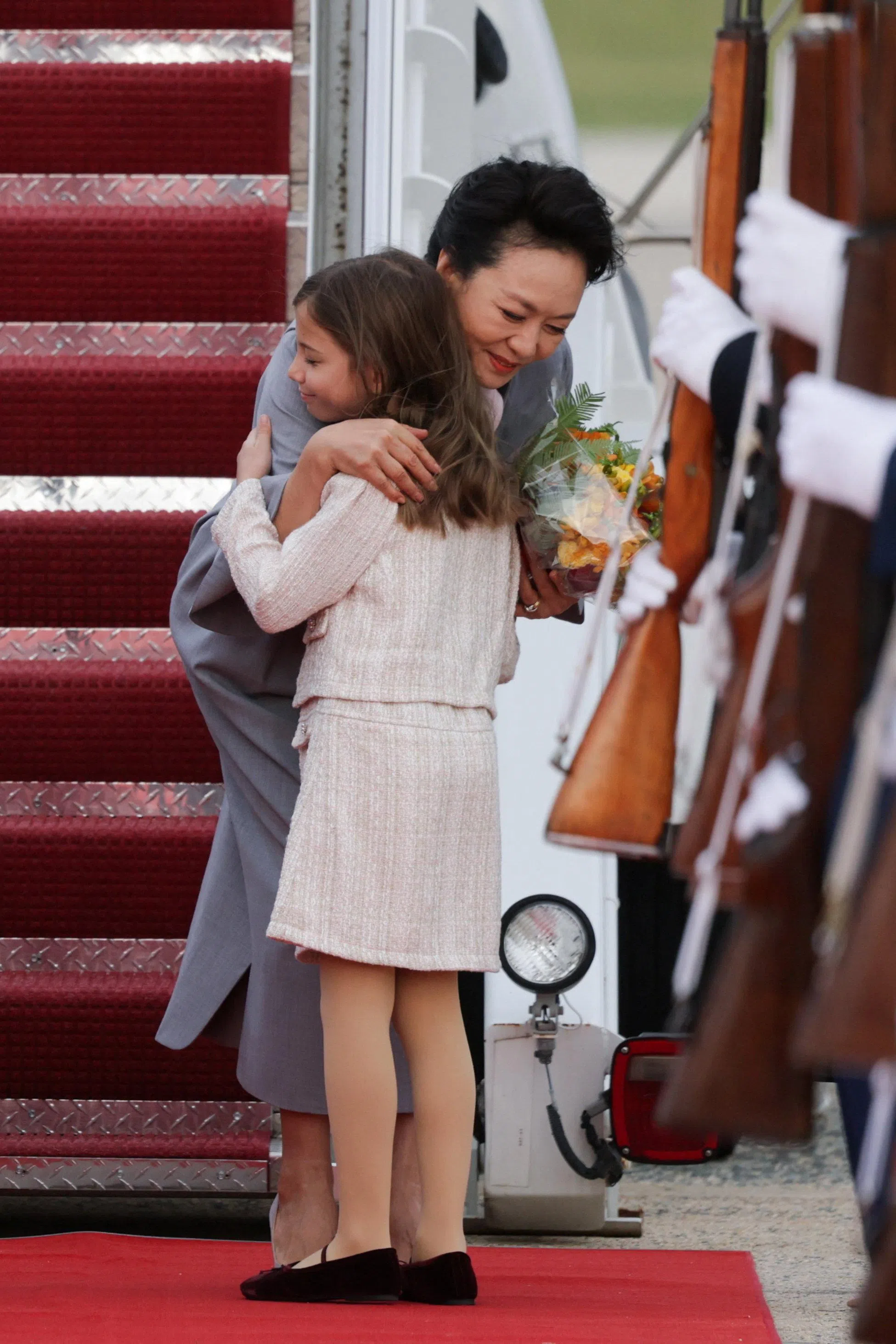 中国国家主席习近平的夫人彭丽媛当地时间9月23日抵达美国马里兰州安德鲁斯联合基地，在专机舷梯旁俯身拥抱一名迎宾女孩。她随习近平赴美进行国事访问。（路透社）