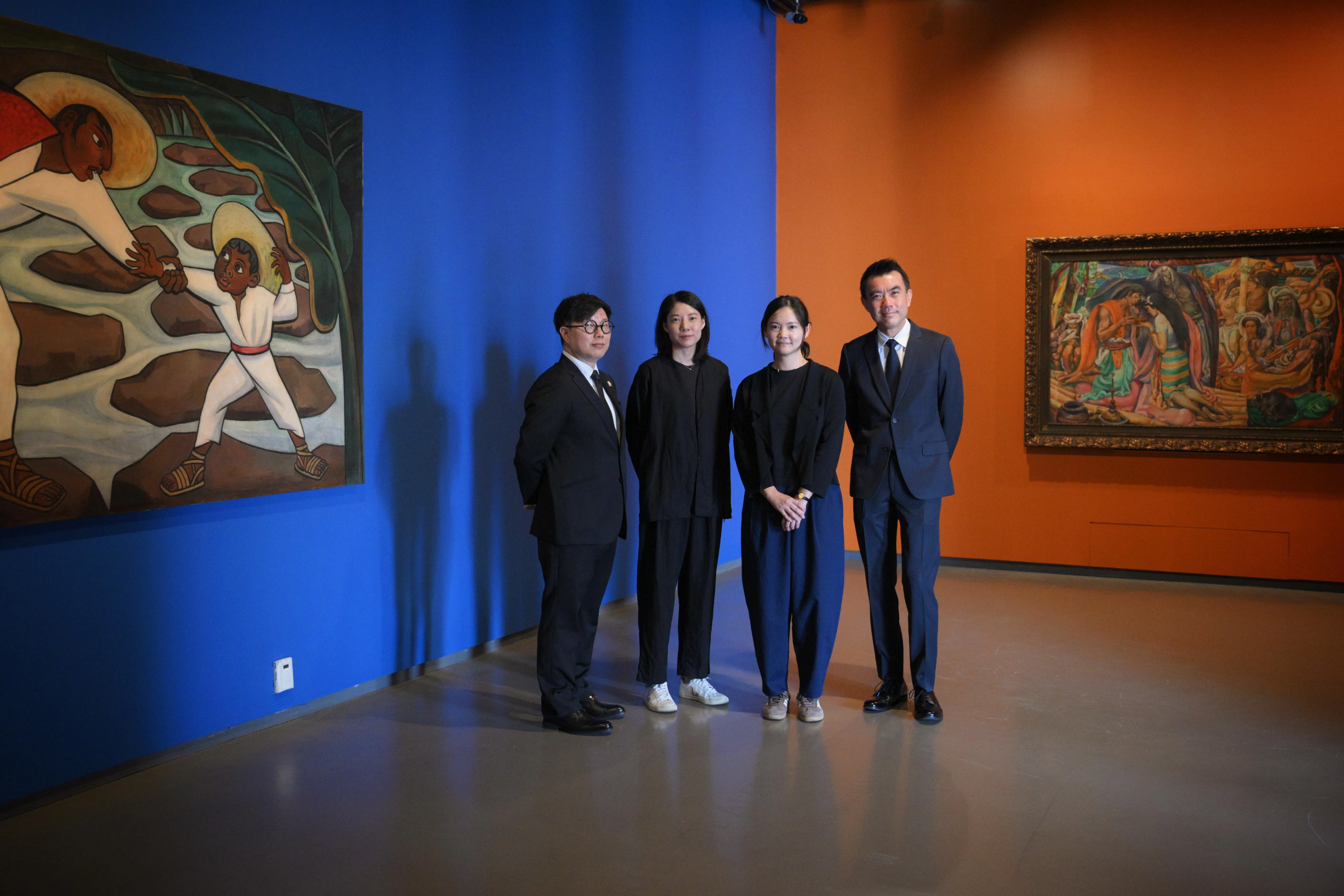 亚洲文明博物馆馆长温俊玉（左起）、新加坡国家美术馆策展人张慧敏、郑嘉韵、馆长兼总裁陈维德在学院三楼热带部分合影。里维拉壁画式油画（左）与菲律宾弗朗西斯科油画对话。（海峡时报）