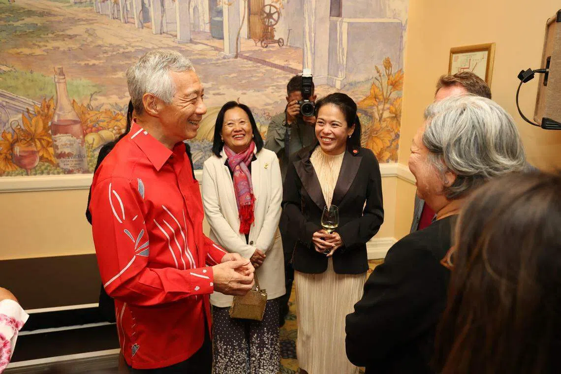 在开普敦经营脚车店的“南非新加坡人”脸书群组负责人张翠芬（左三），在招待会上同李显龙总理（左一）交流。（何家俊摄）