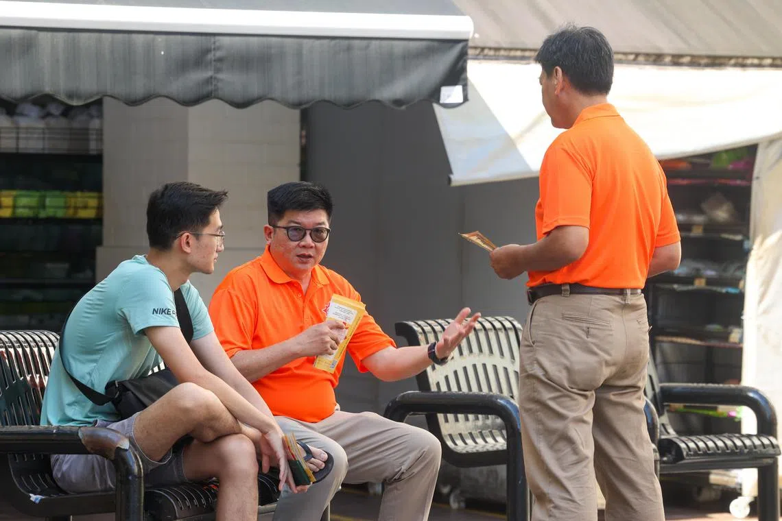 国民团结党秘书长冯展良（中）星期天走访淡滨尼集选区，与居民交谈。（吴先邦摄）