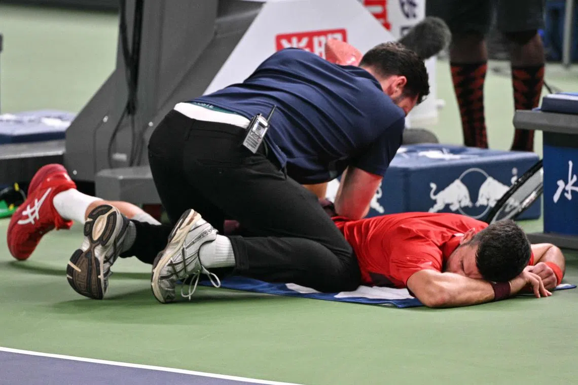 乔科维奇（红衣）在次盘5比6落后时，一度因身体不适叫了医疗暂停。（法新社）