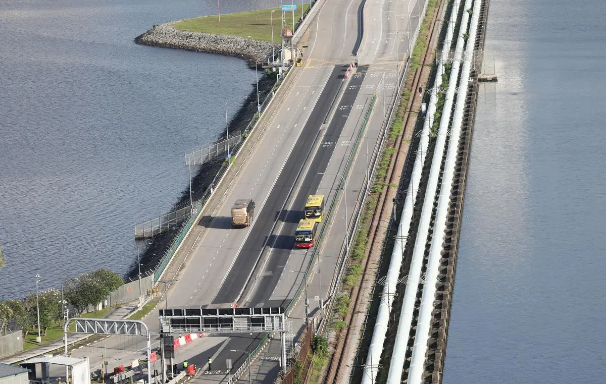 2021年11月29日新马VTL首趟开往马来西亚新山的星运旅游巴士，与首趟开过来新加坡的汉达英达巴士在新柔长堤“相会”。（何炳耀摄）