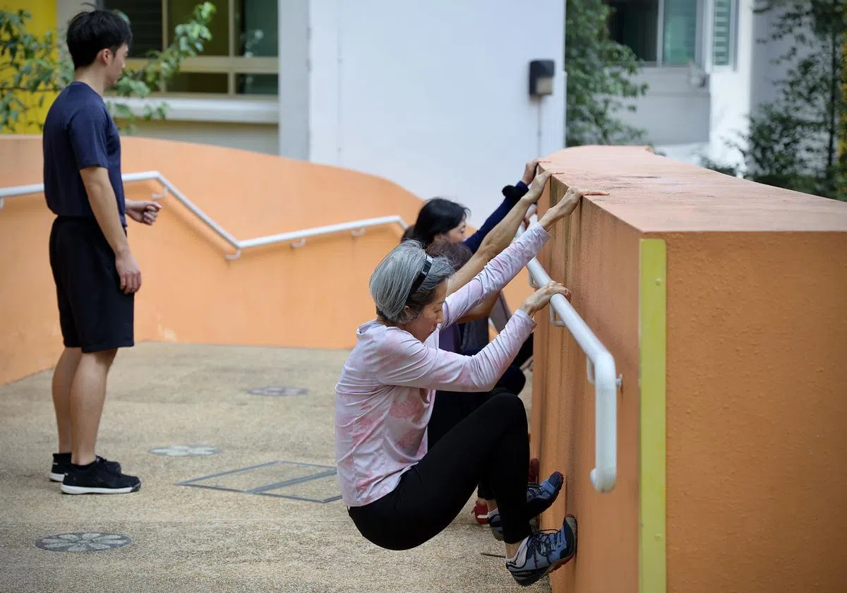 日常训练，抓住栏杆扶手向上爬，练习手臂和腿部力量。（龙国雄／摄）