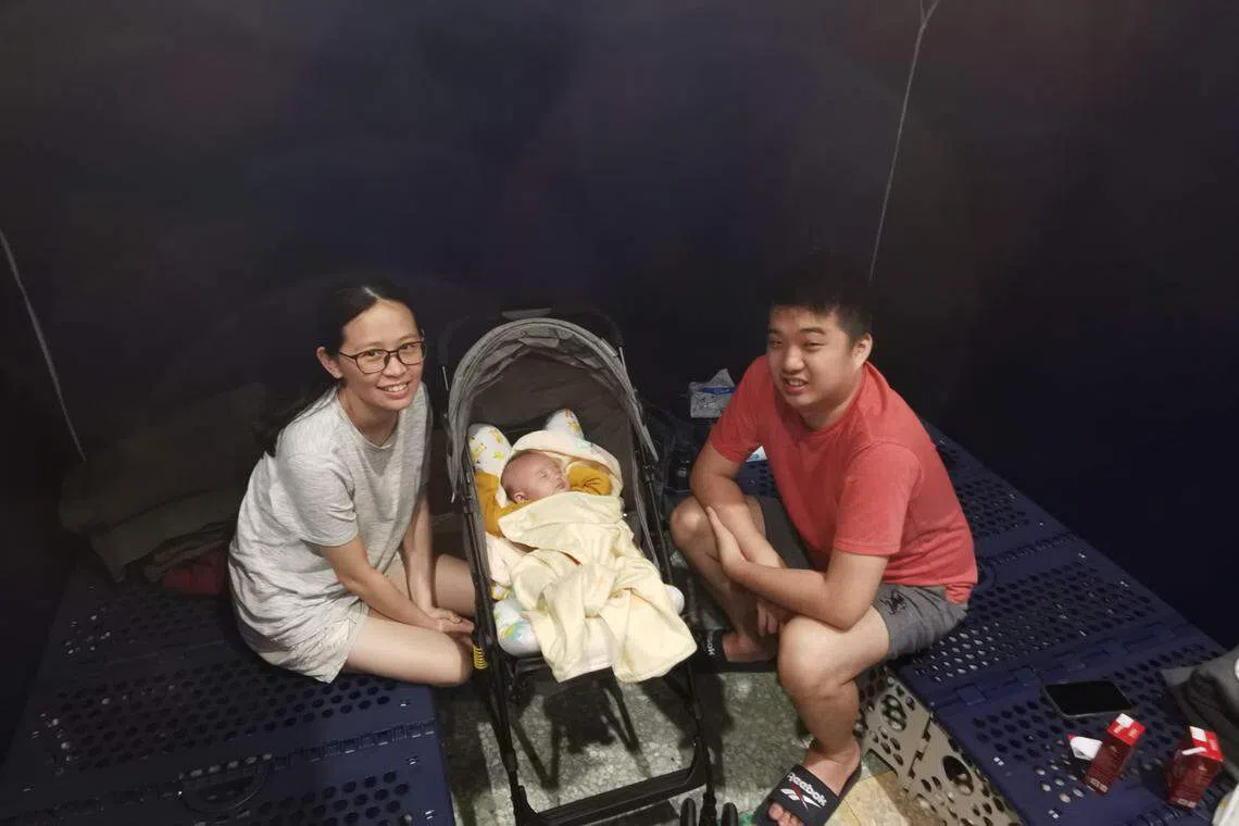 来自印尼的东华大学助理教授张汉利一家三口，包括两个月大的女儿，在安心关怀站的帐篷隔间里避难。（温伟中摄）