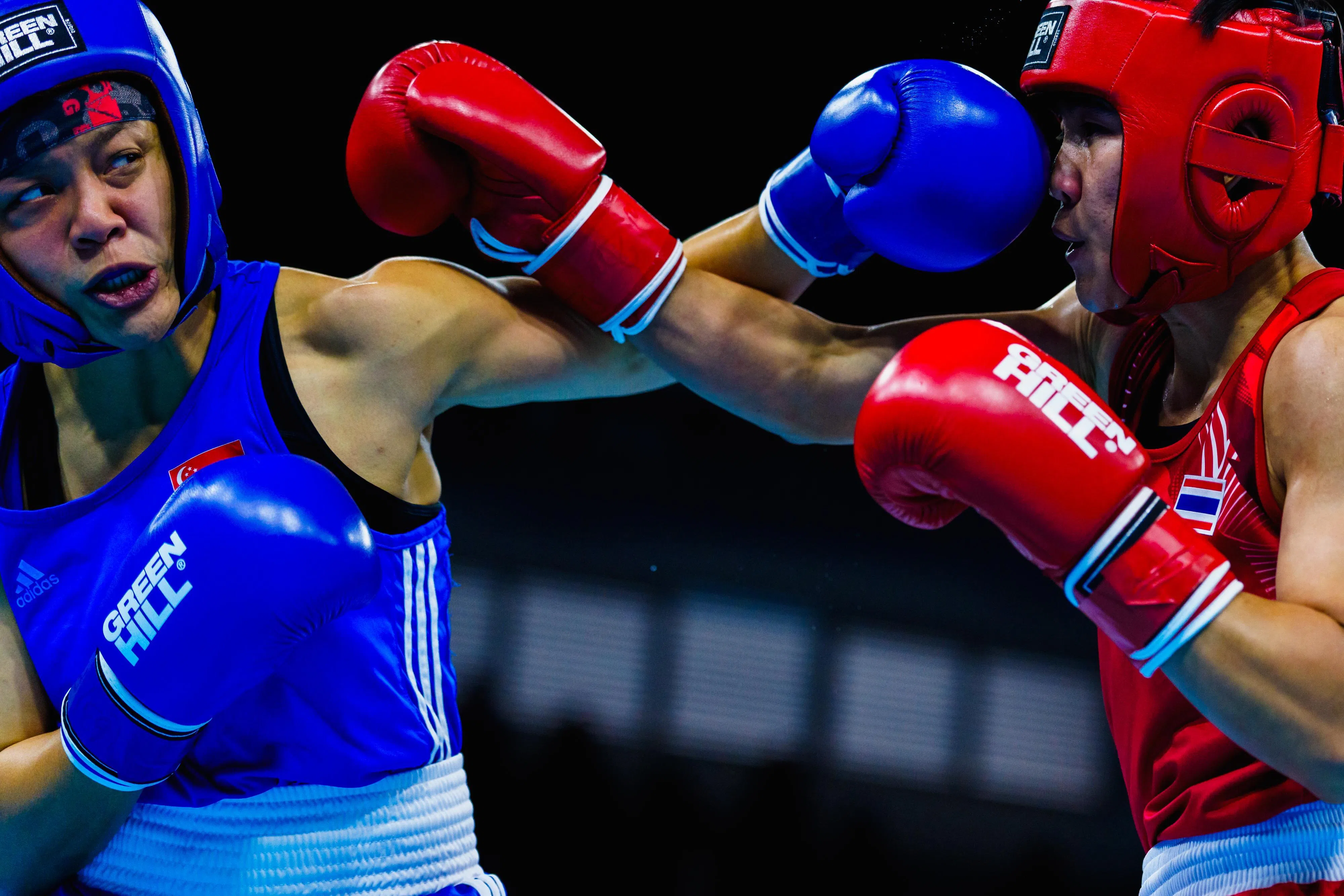 秀月（左）在决赛中一拳击中对手脸部。（新加坡体育理事会提供）