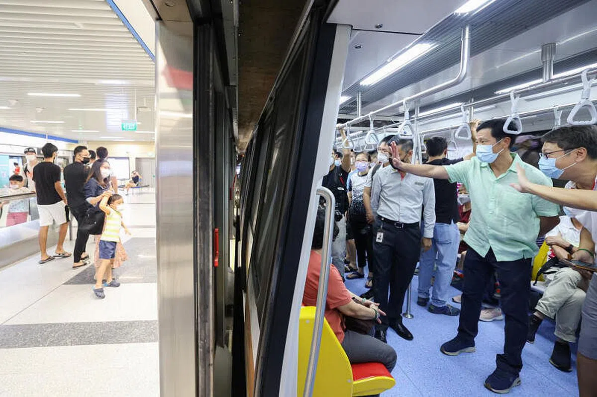 地铁汤申—东海岸线第三阶段11个地铁站于2022年11月13日正式通车，卫生部长王乙康（右二）和同为三巴旺集选区议员的傅丽珊和维凯，以及约100名居民试搭这条地铁线。图为王乙康等人向车厢外的民众挥手打招呼。（李冠卫摄）