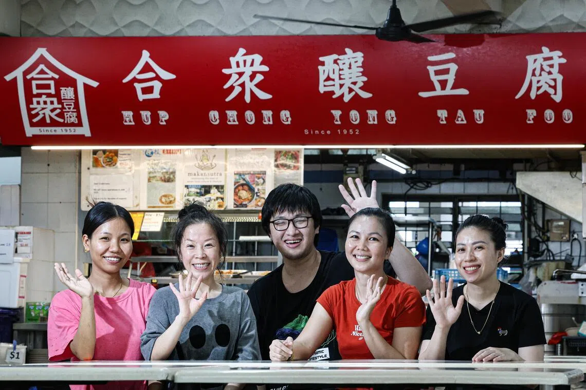 随着午餐时段结束，合众酿豆腐摊位的员工约下午三时开始收拾，并与老板娘卢美文（左四）合影留念。（关俊威摄）