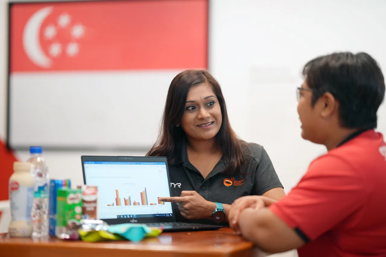 运动营养师帕里玛拉（左）向我国残奥射箭代表塞西达讲解营养知识。（谢智扬摄）