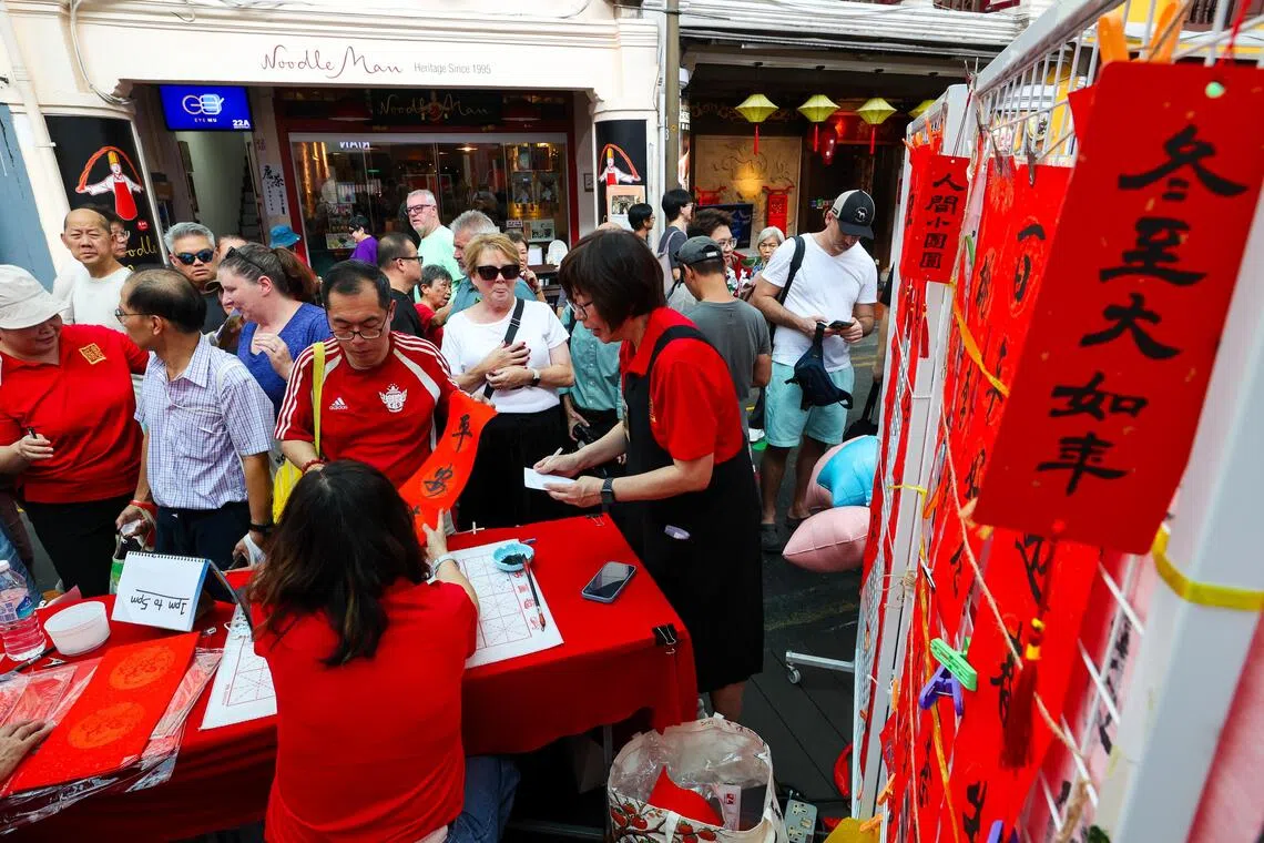 冬至是二十四节气之一，有“冬至大过年”的说法。图为牛车水冬至活动中的现场挥春。（林明顺摄）