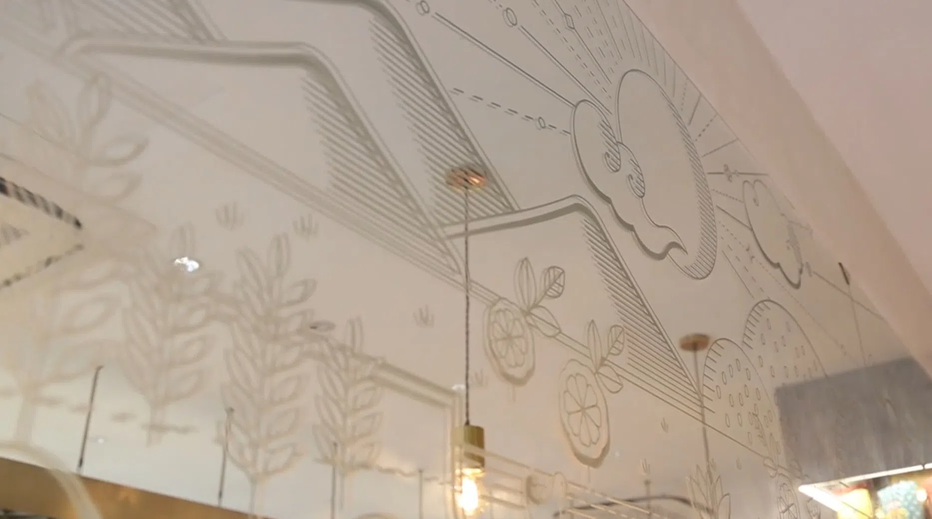 东兴店内的镜子上贴着一副“山水画”，她说每个图案实则都代表店内的一种点心。（视频截图）