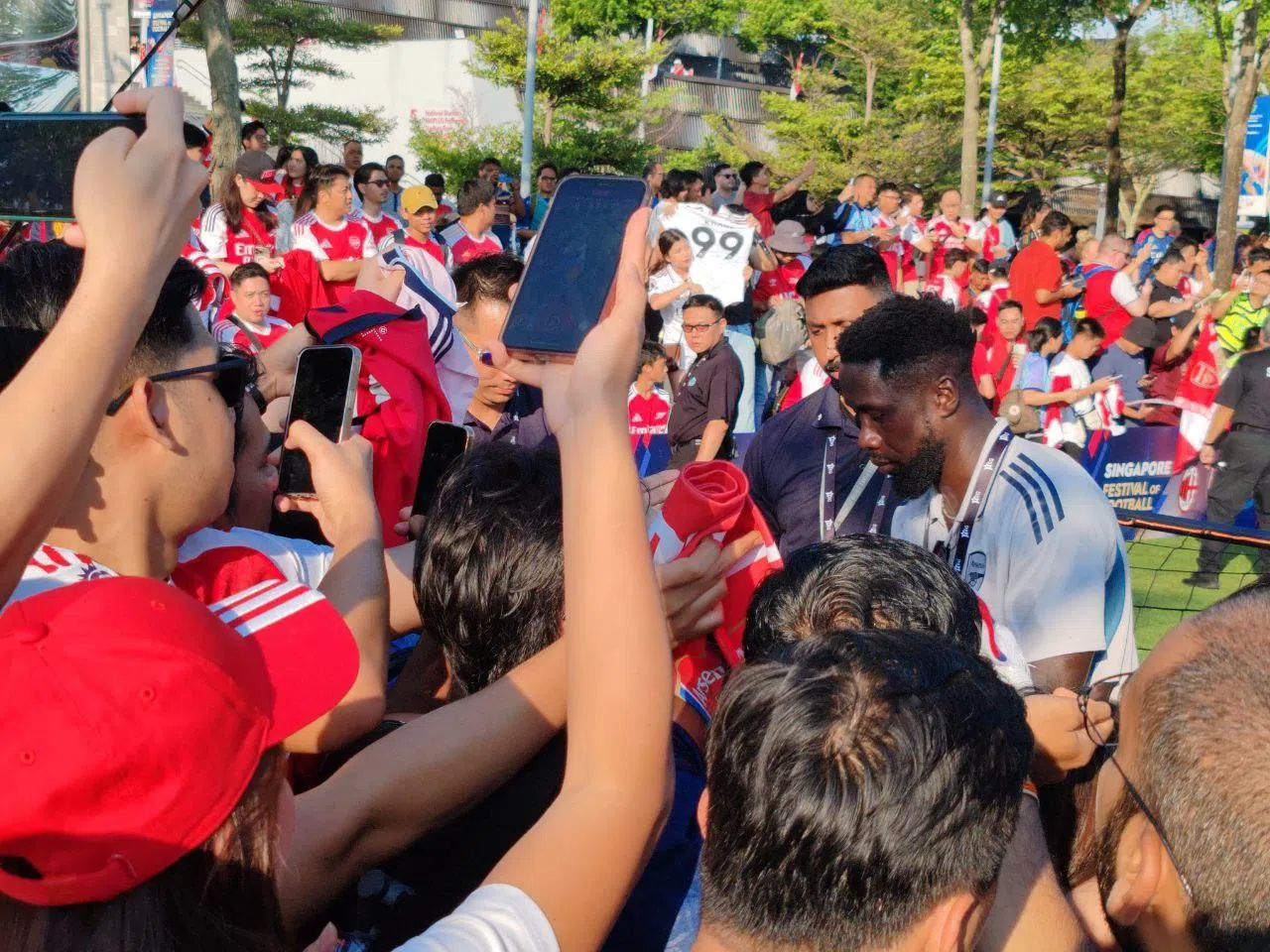 阿申纳名宿萨尼亚在赛前为球迷签名。（陈明耀摄）