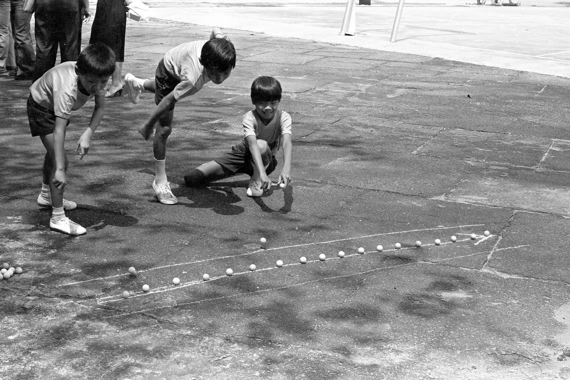 男孩儿的游戏——打“Goli”（弹珠）。一排弹珠，三两玩伴，互相挑战，满满童趣。（档案照片）