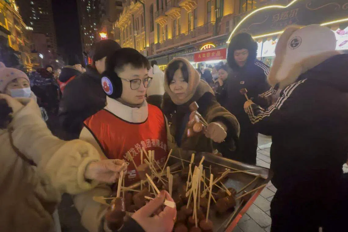 哈尔滨市民对游客的热情款待在社交媒体被放大，使各地网民心生向往。图为有哈尔滨企业在中央大街免费为游客提供红肠。（林煇智摄）