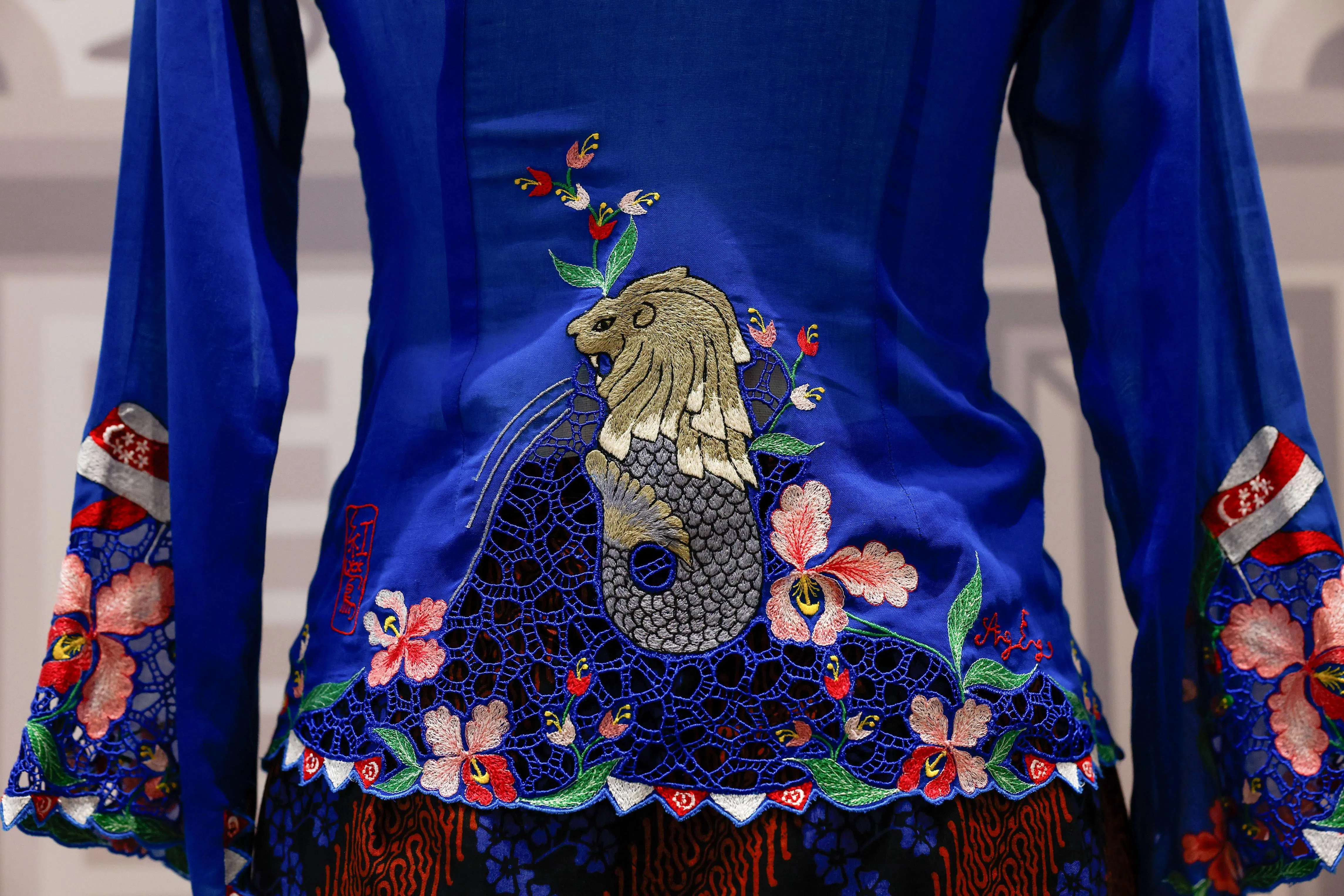 获新加坡、马来西亚、文莱、印尼和泰国联合提名的东南亚妇女传统服饰卡峇雅2024年12月成功列入联合国教科文组织非物质文化遗产代表名录。图为马来西亚娘惹卡峇雅设计师林幼琳设计的新加坡鱼尾狮图案卡峇雅。（马新社）