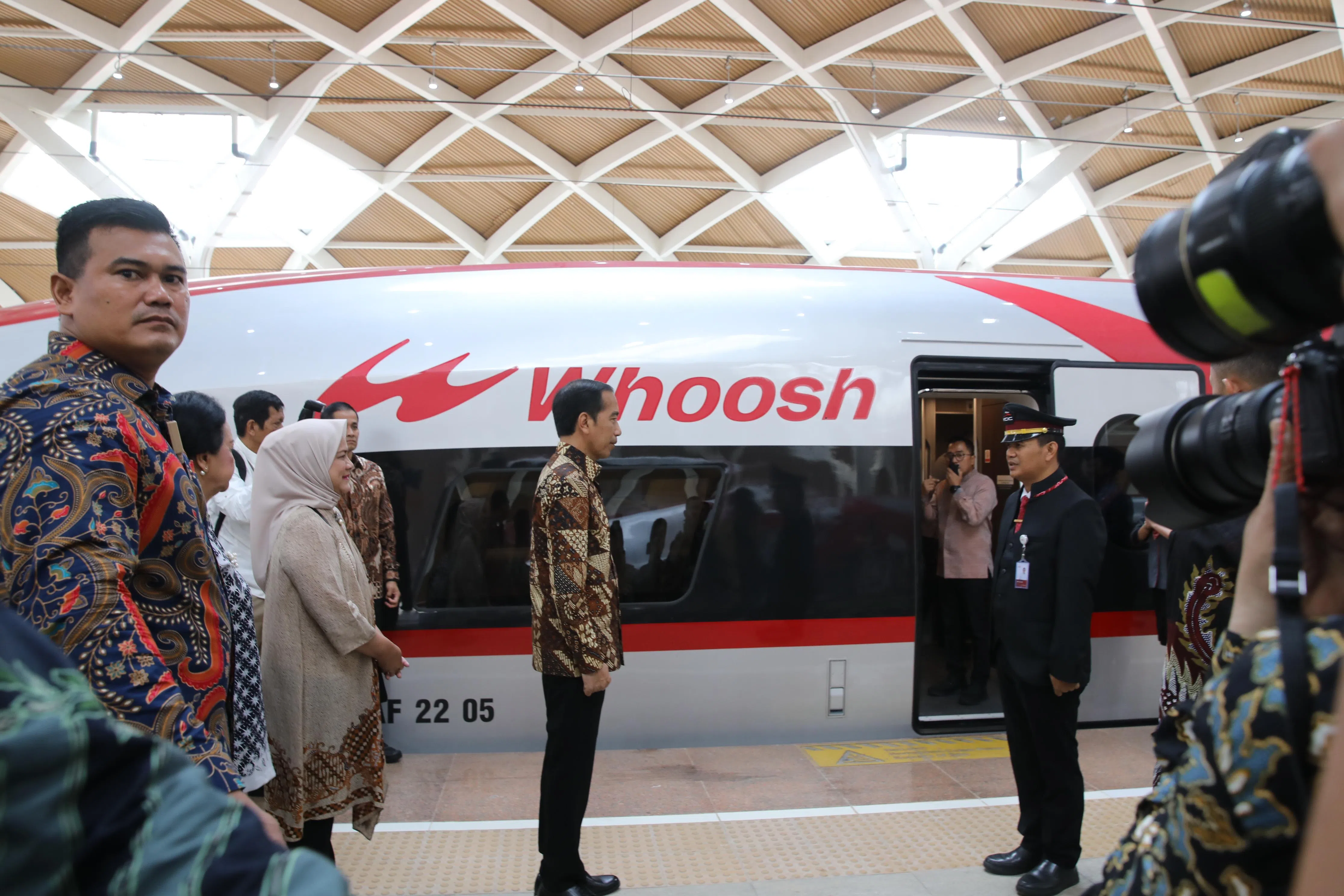 印度尼西亚总统佐科（中）在雅加达高铁站宣布雅万高铁正式启用，图为车长登上列车前向佐科报告。（中新社）
