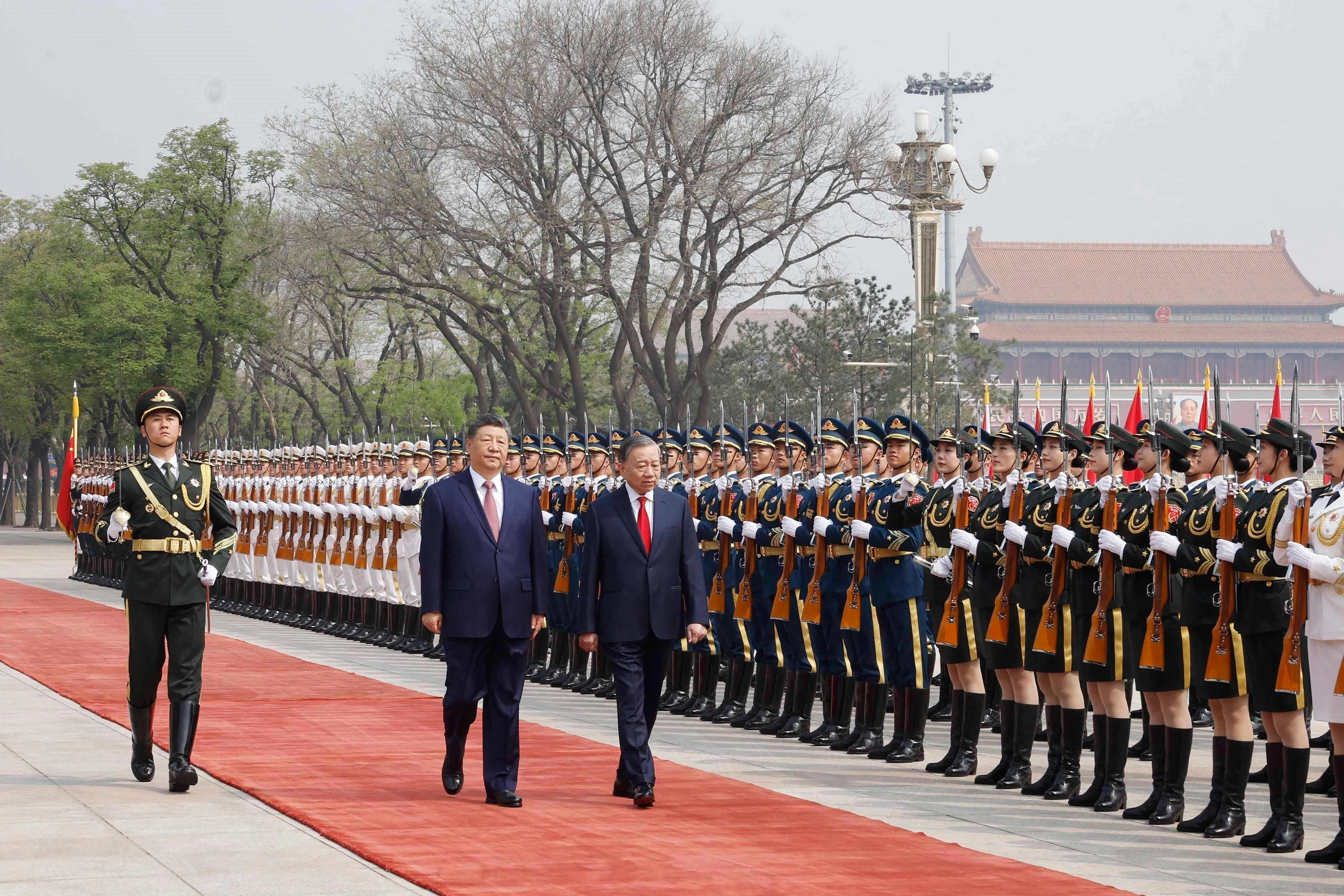 4月15日，中国国家主席习近平（中）和越南国家主席苏林在北京人民大会堂检阅仪仗队。（法新社）