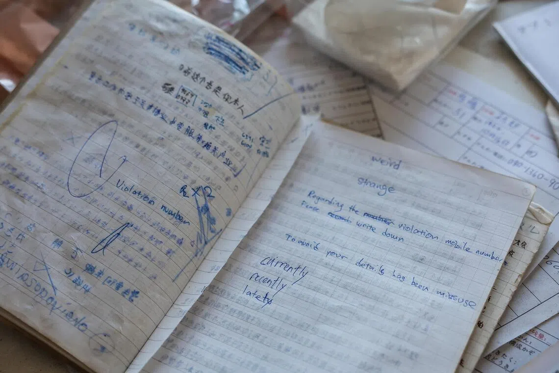 调查人员搜获一些文件，看似诈骗对话脚本和对话记录簿。（路透社）