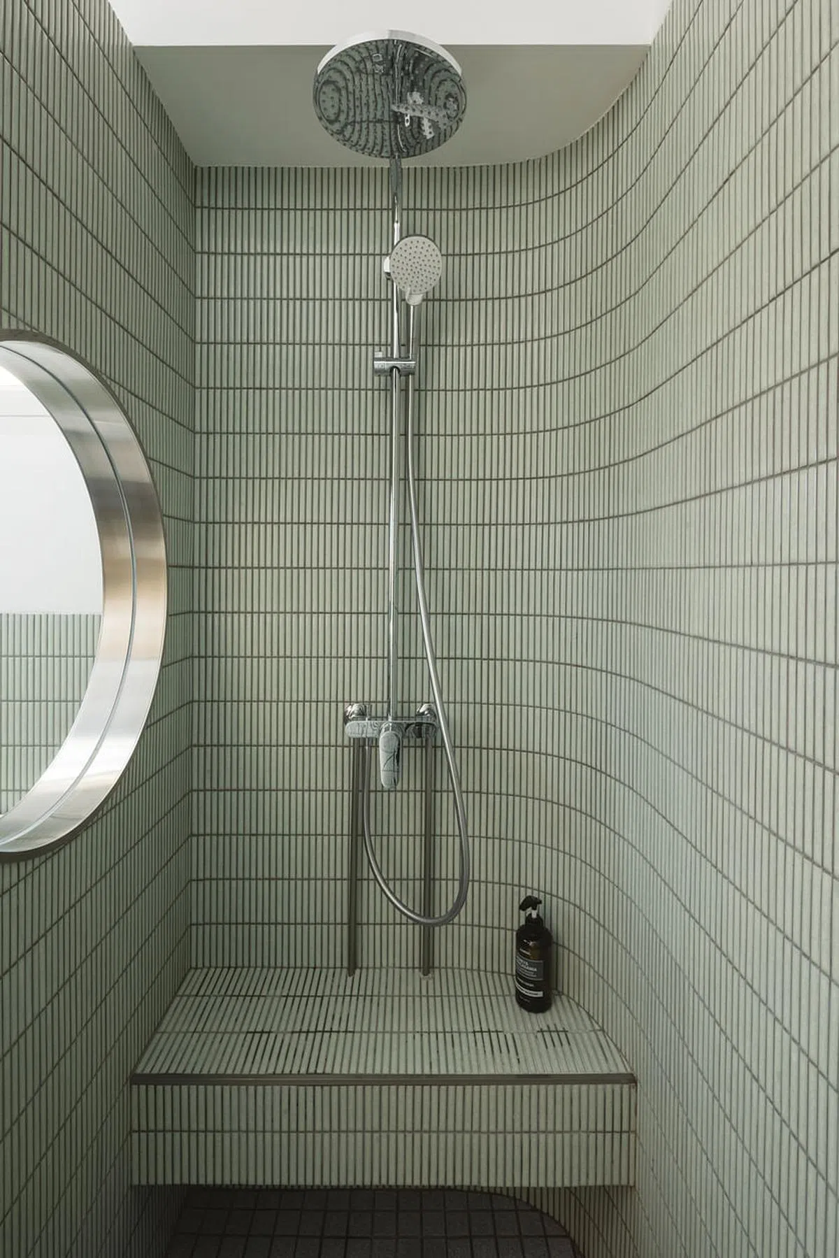 沐浴间的墙面做弧形处理，还设有可让屋主坐着洗澡的瓷砖座位。（Monocot Studio提供照片）