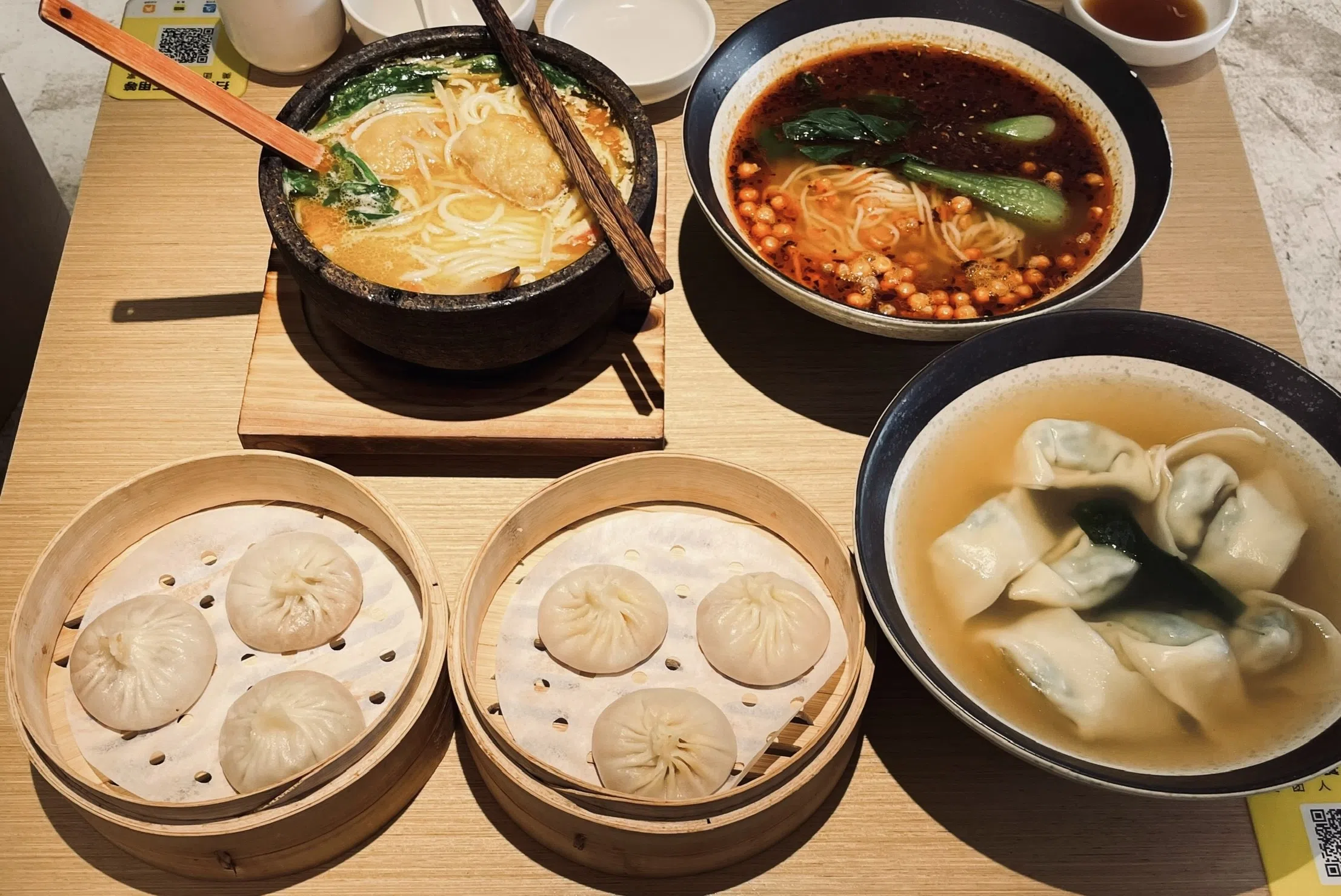 上海素食餐馆“舞蔬尚饺”的罐汤小笼包、馄饨汤、重庆小面和过桥米线。（周佳铃摄）