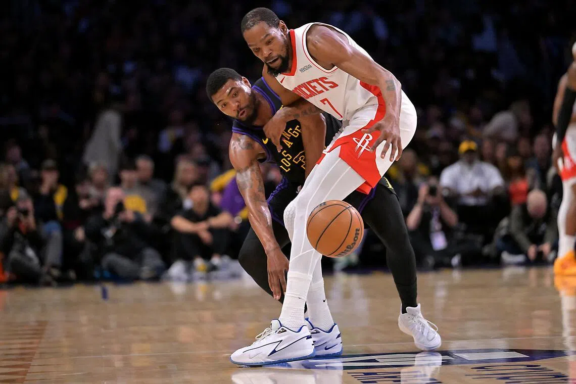 在湖人前锋斯玛特（左）的贴身防守下，火箭球星杜兰特（右）几乎没有投篮空间，屡屡出现掉球失误。（路透社）