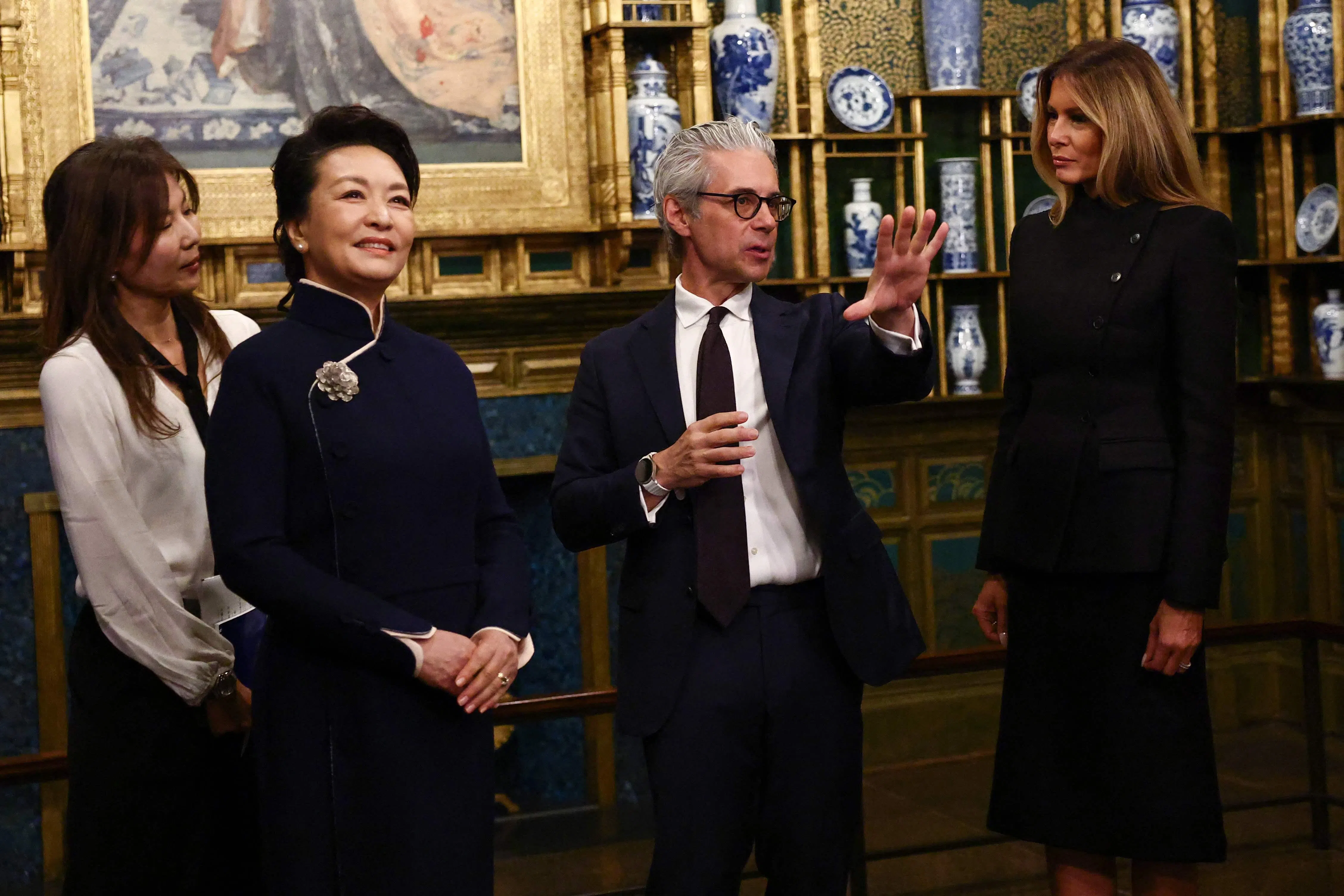 梅拉尼娅（右）与彭丽媛在华盛顿参观史密森尼国立亚洲艺术博物馆时，听取馆长蔡斯·罗宾逊（右二）的讲解。（法新社）