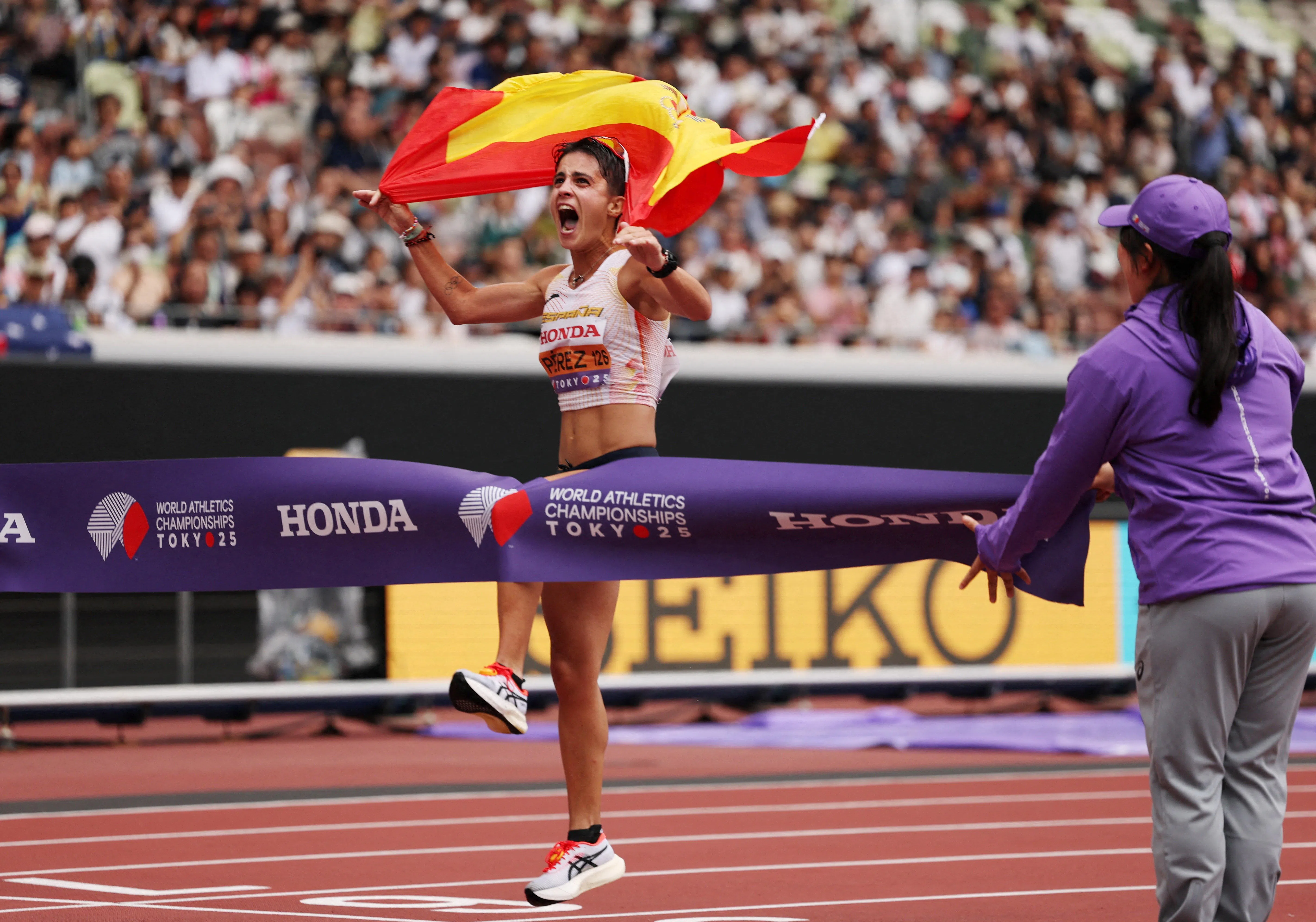 玛丽亚·佩雷斯冲线时举起国旗欢呼庆祝。（路透社）