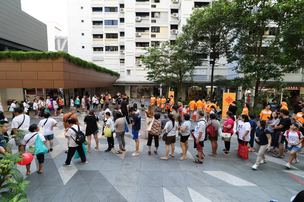 国民团结党团队星期天走访海军部村庄，现场一度有约70名居民排队领取榴梿。（梁麒麟摄）