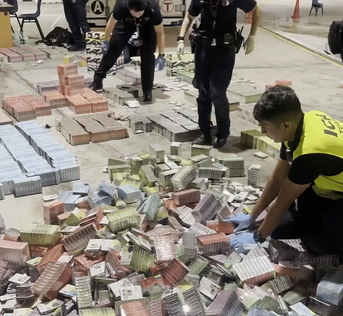 移民与关卡局人员在大士关卡检查一辆载着冷冻鸡块的货车时，发现司机后座藏着多个用黑色塑料袋包裹的箱子，最终起获约2600个电子烟枪和约2万7006个电子烟弹。（取自移民与关卡局脸书）