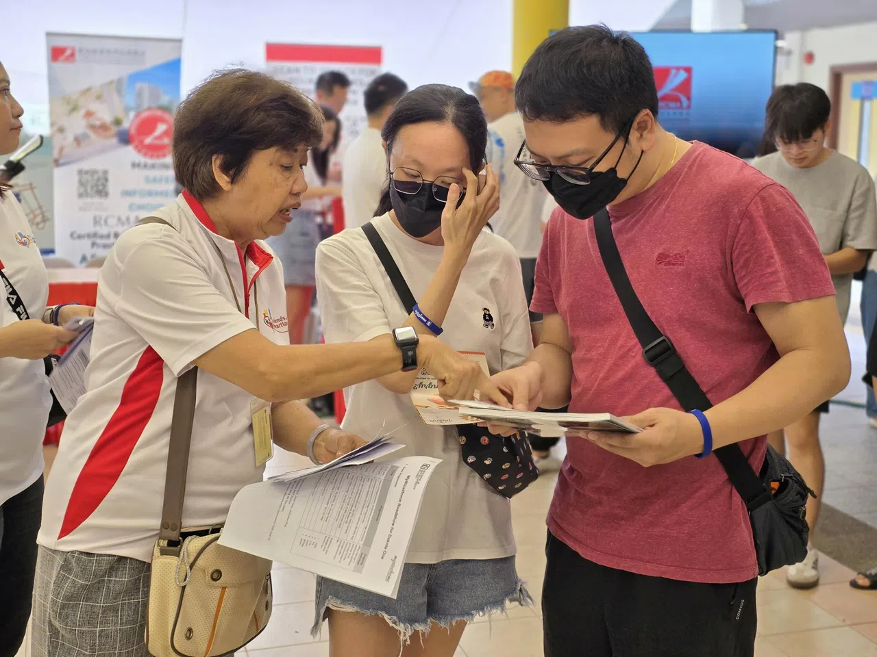 5月于加东民众俱乐部举行的“温馨我家”路演上，陈霞影（左一）向未来搬入这一区的居民，讲解芽笼Dakota One预购组屋项目。（建屋发展局提供）