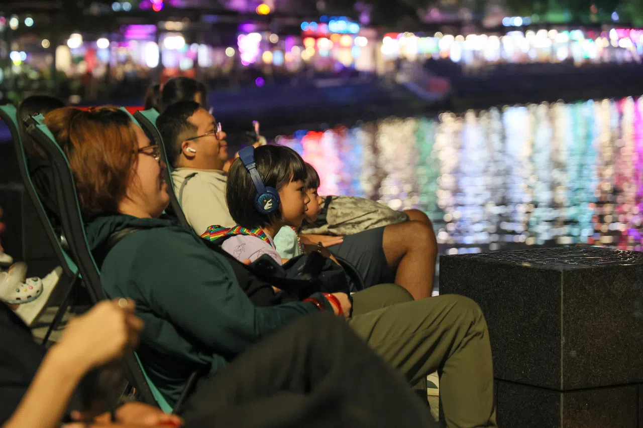 一家大小可坐在新加坡河畔的躺椅上，观赏河对岸投影在大树上的沉浸式剧场“梦河历程”，边听着语音导览解说，在星空下、光影间、波光粼粼的河面上，感受新加坡河的过去与未来。（张俊杰摄）